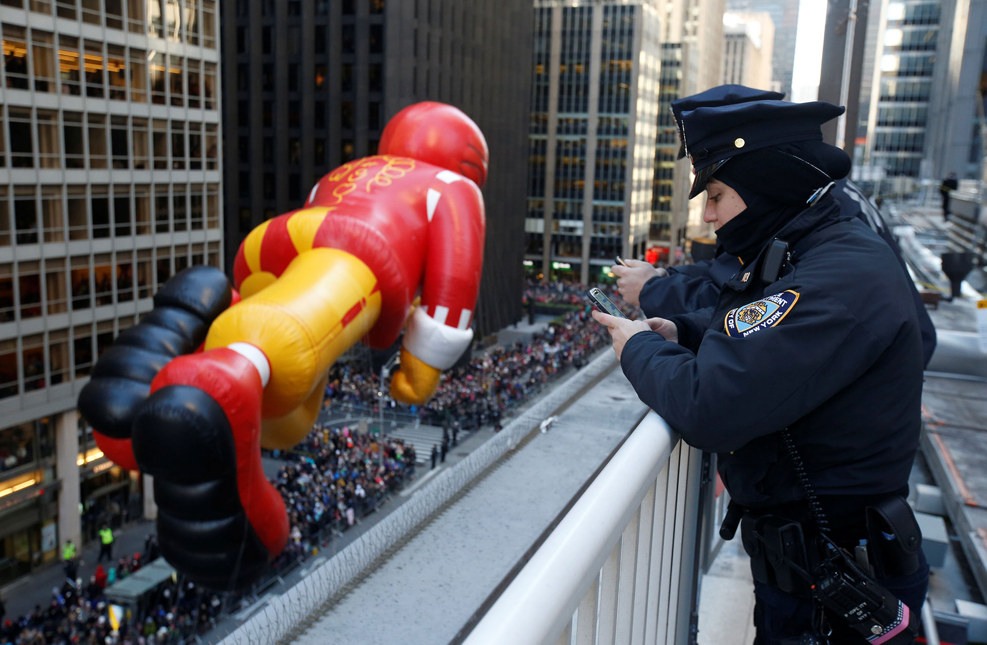 Los oficiales del Departamento de Policía de la Ciudad de Nueva York observan cómo el globo de Ronald McDonald desciende por la Sexta Avenida durante el Desfile del Día de Acción de Gracias de Macy’s en el distrito de Manhattan de la ciudad de Nueva York, The York, Estados Unidos, el 23 de noviembre de 2017. (Reuters)