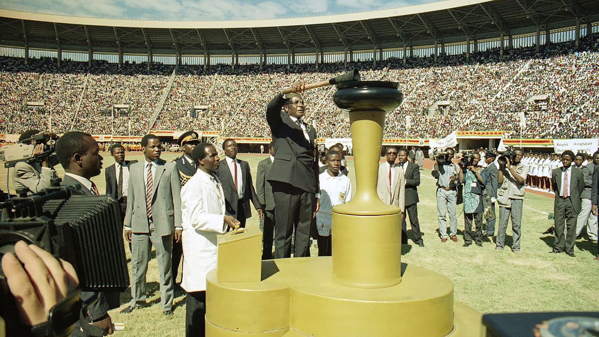 Mugabe enciende una llama para celebrar el décimo aniversario de la independencia de la nación, en el National Sports Center de Harare el 18 de abril de 1990.