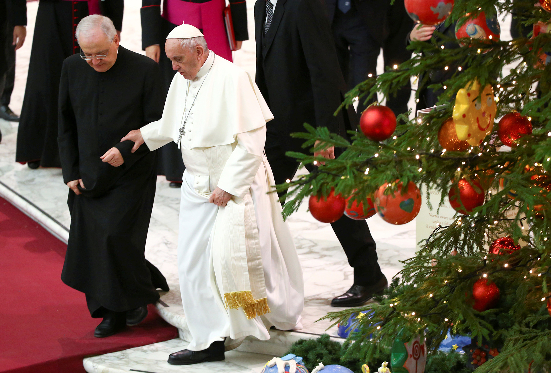 El papa Francisco camina asistido al pasar cerca al árbol del Vaticano, en la plaza San Pedro