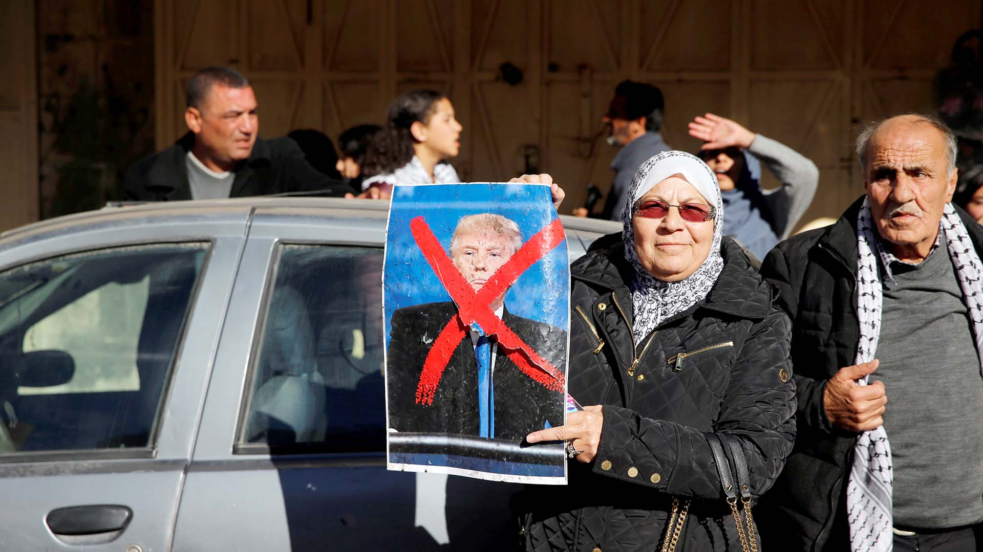 Una mujer sostiene una foto del presidente Donald Trump en una calle durante una manifestación en el este de Jerusalén el 9 de diciembre de 2017. (Reuters)