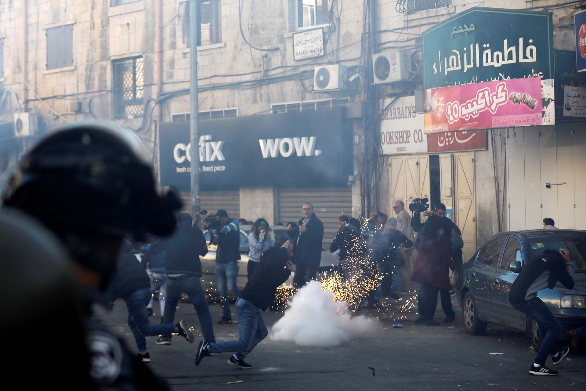 Manifestantes reaccionan cuando estalla una granada aturdidora durante una manifestación en una calle al este de Jerusalén el 9 de diciembre de 2017. (Reuters)