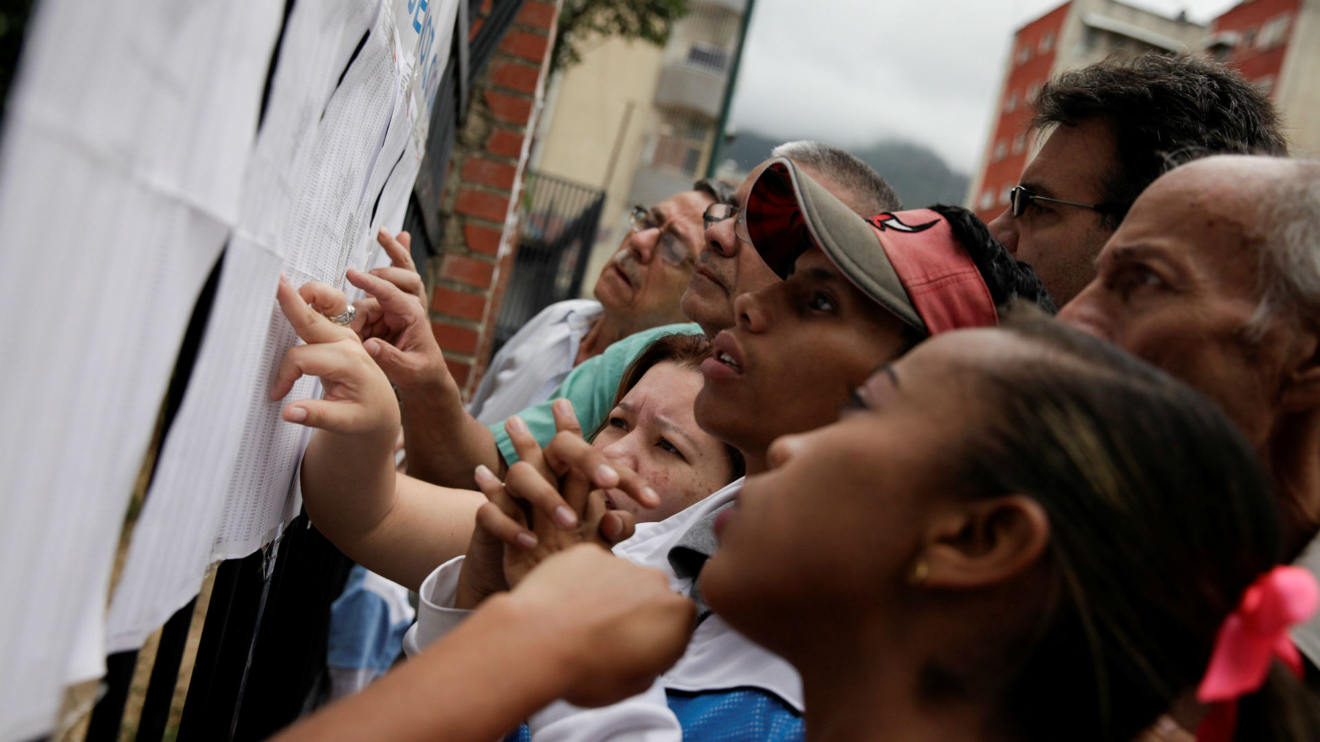 Ciudadanos miran las listas electorales en Caracas (Reuters)