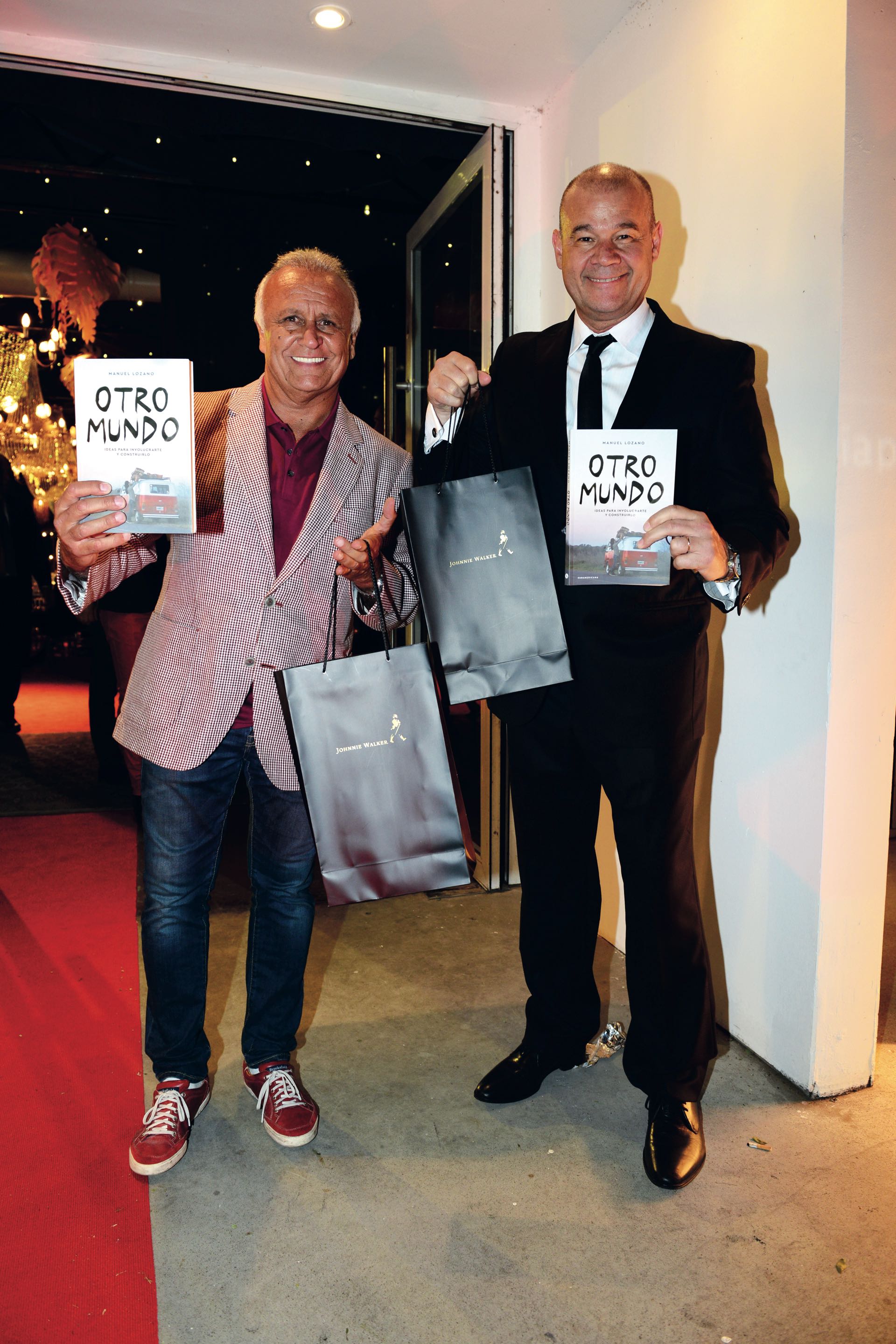 Miguel del Sel y el Chino Volpato con sus regalos de despedida: el libro Otro mundo, de Manuel Lozano, y una botella de Johnnie Walker Gold Reserve.