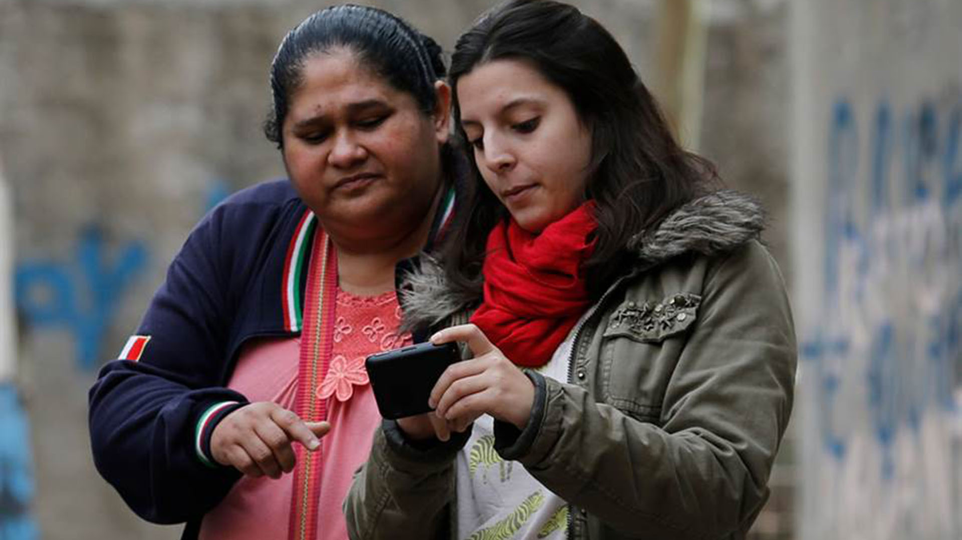 Rosario Fassina, socióloga de ACIJ, junto a vecinos de los barrios, realizando un mapeo de las calles con un dispositivo GPS