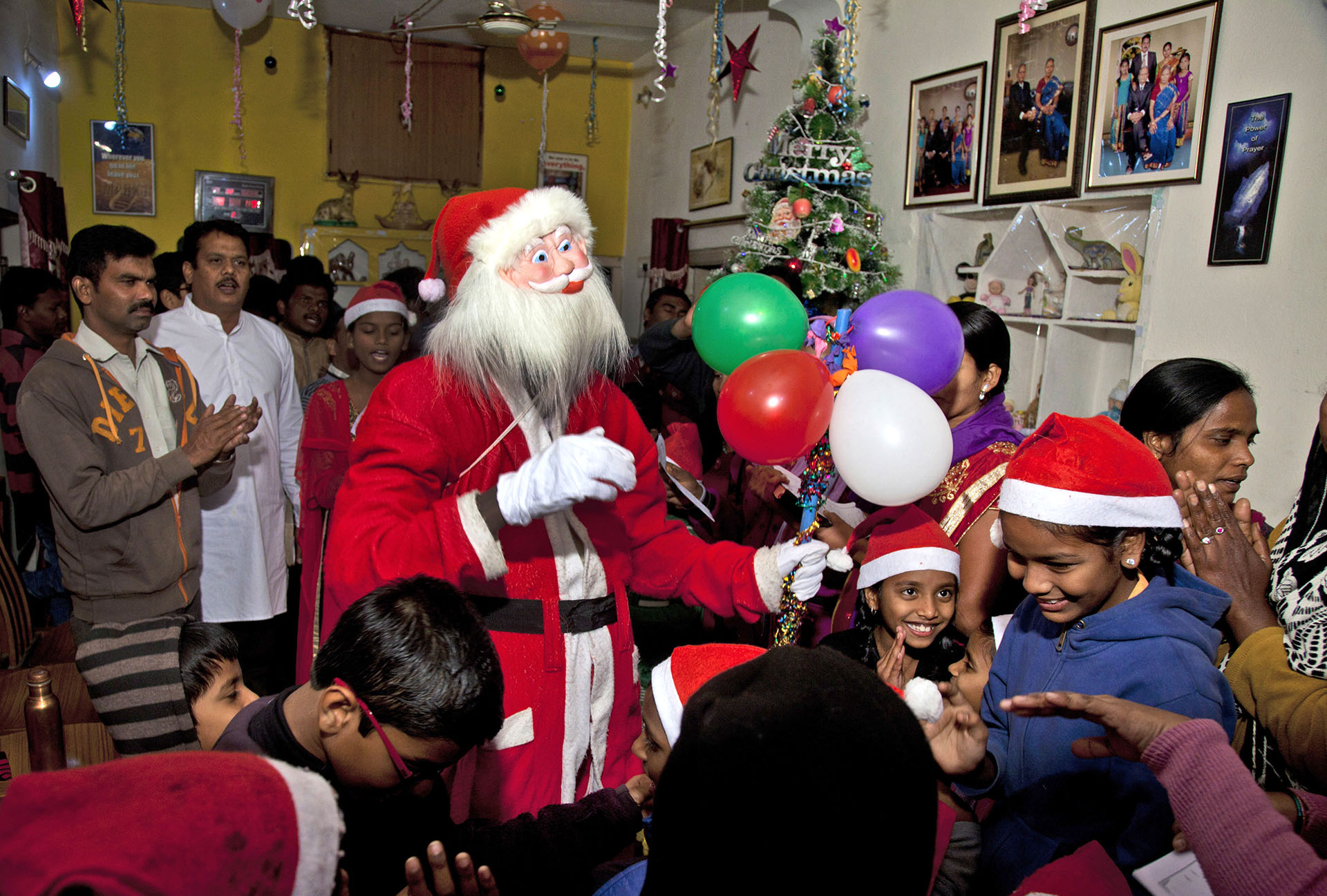 un indio vestido de Santa Claus canta villancicos navideños con niños en Hyderabad, India, el 19 de diciembre de 2017. (AP)