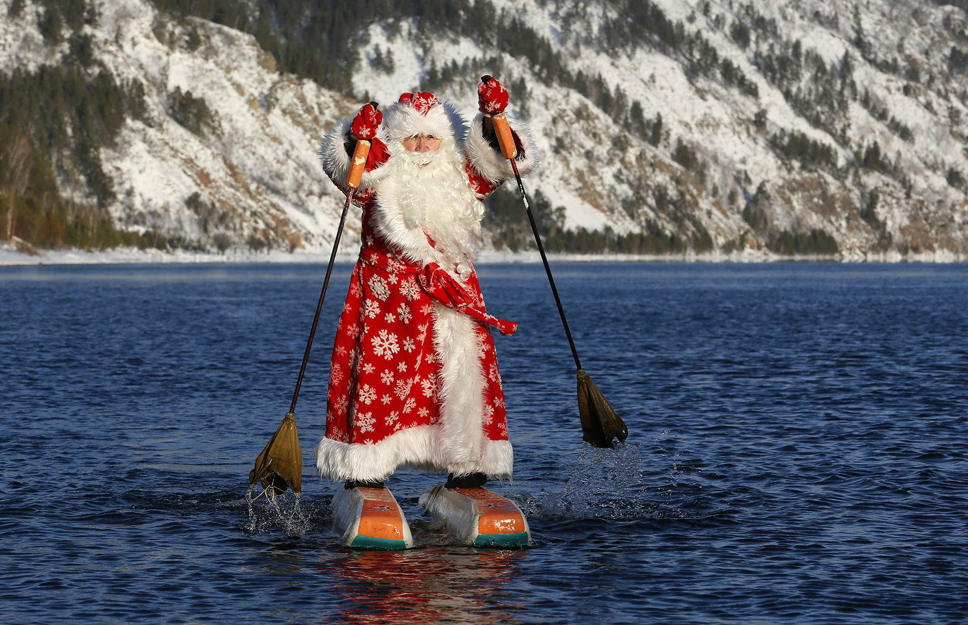 Nikolai Vasilyev, de 64 años, vestido como el padre Frost, el equivalente ruso de Santa Claus, hace esquí acuático a lo largo del río Yenisei, en las afueras de la ciudad siberiana de Krasnoyarsk, Rusia, el 19 de diciembre de 2017. (Reuters)