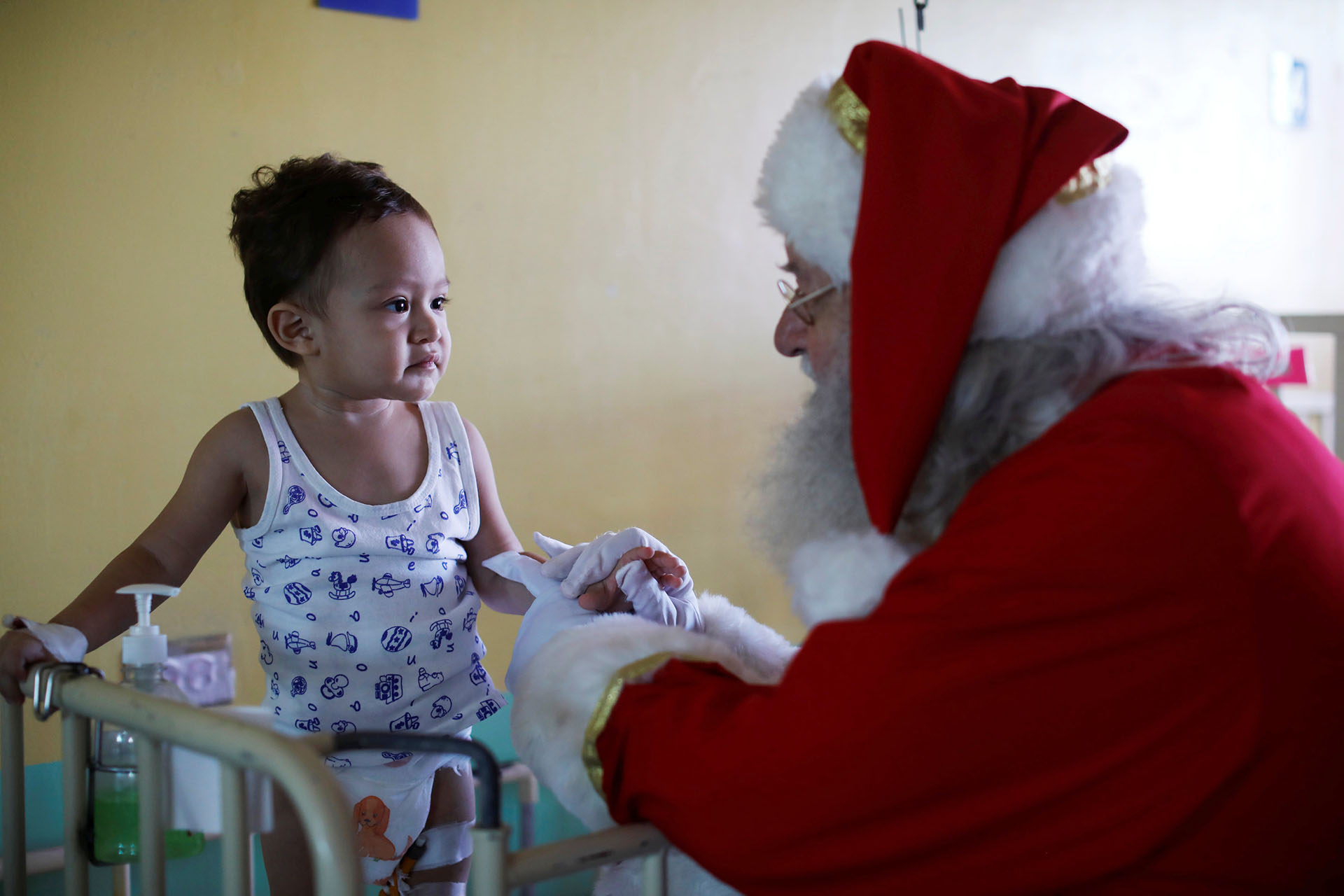 El islandés Einar Sveinsson, vestido de Papá Noel, habla con Javier Steven Cabrera Henríquez durante una visita al Benjamin Bloom National Children Hospital en San Salvador, El Salvador, el 18 de diciembre de 2017. (Reuters)