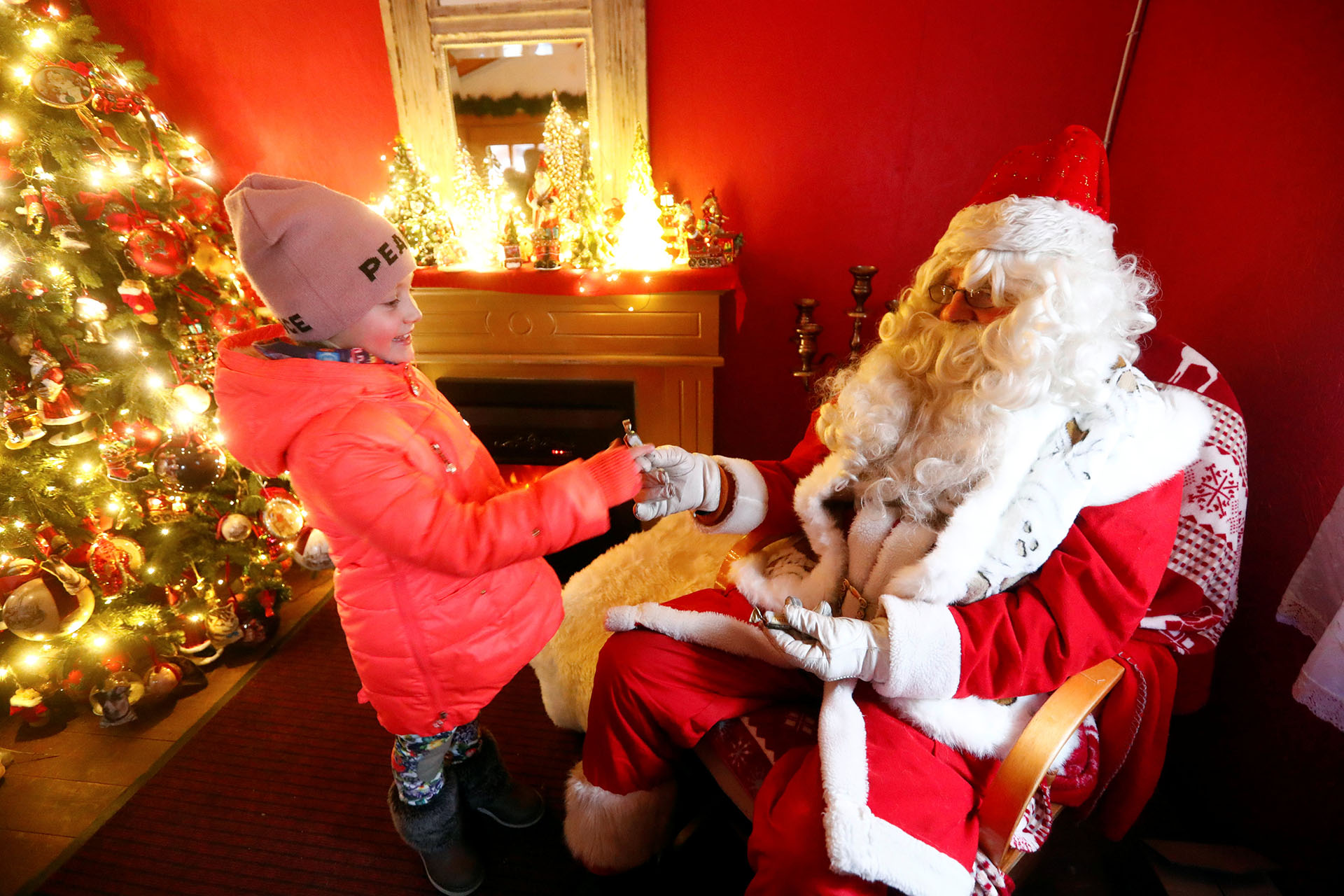 Un hombre vestido de Papá Noel da dulces a una niña en Tallinn, Estonia 18 de diciembre de 2017. (Reuters)