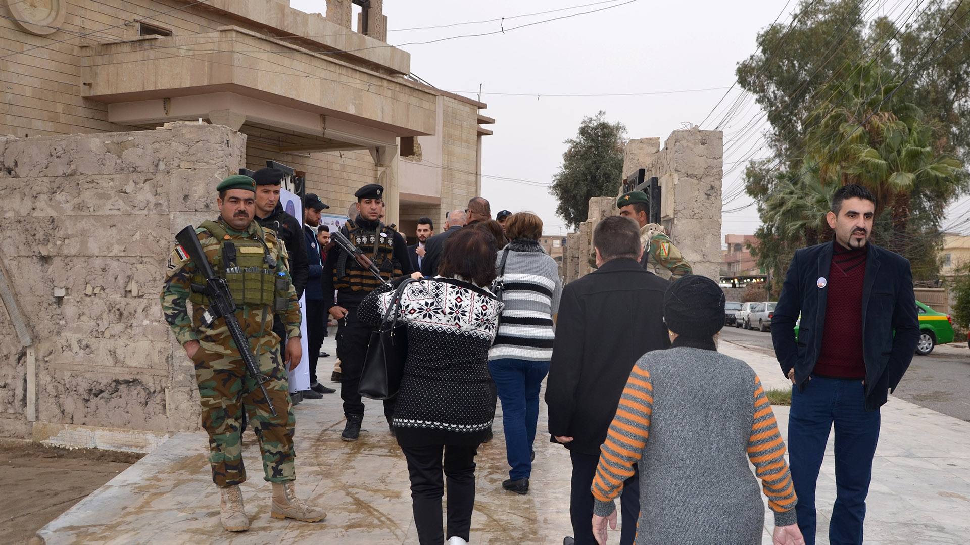 Iraquíes cristianos llegan a la iglesia, custodiados por miembros de las fuerzas de seguridad (AFP)