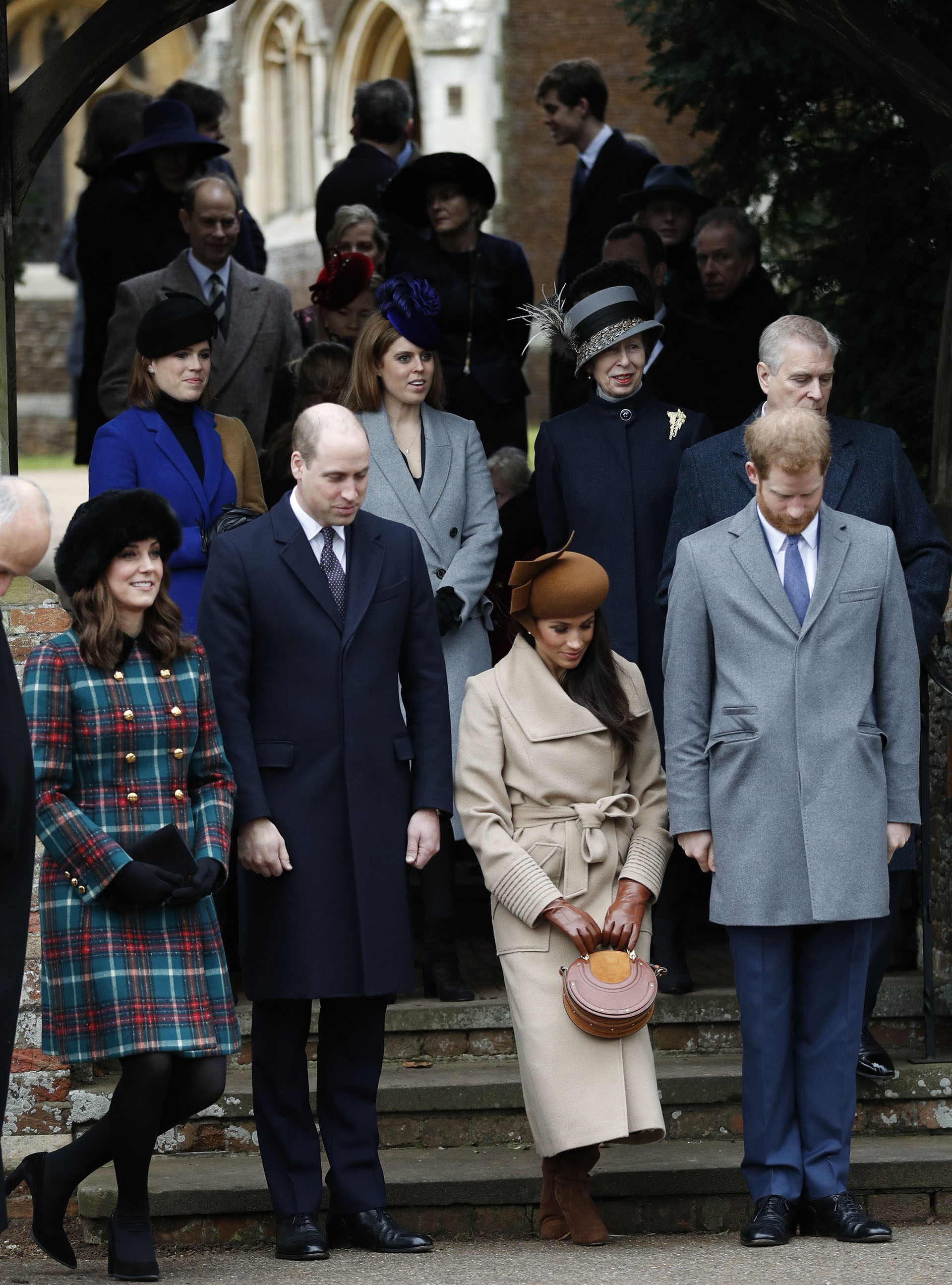 Los integrantes de la familia real: Catalina de Cambridge y su marido, el príncipe Guillermo; la actriz Meghan Markle y su prometido, el príncipe Harry. Detrás, las princesas Beatriz, Eugenia y Ana, junto al príncipe Andrés. Todas las mujeres llamaron la atención con sus elegantes sombreros