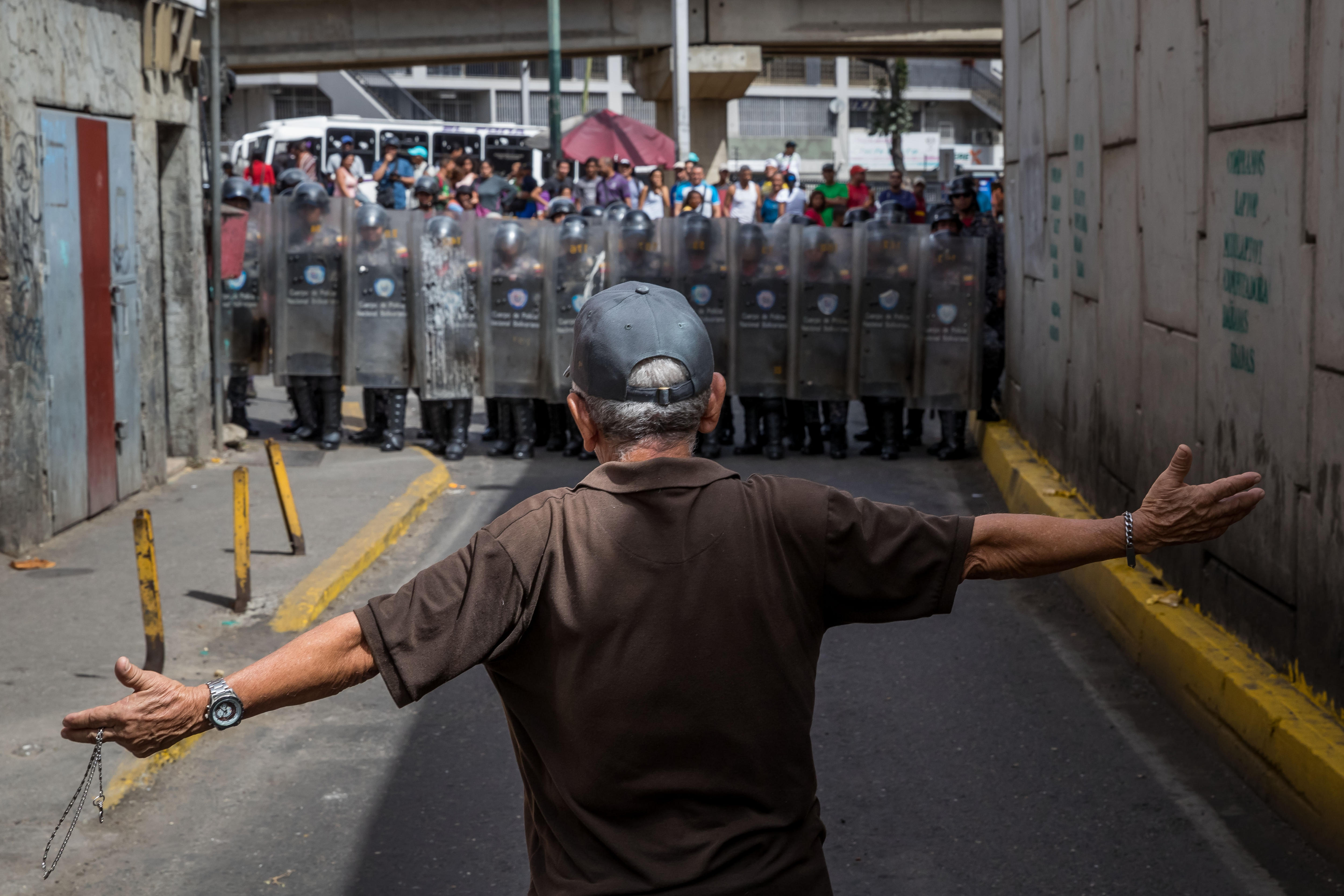 Un hombre protesta frente a miembros de la Policía Nacional Bolivariana (EFE)