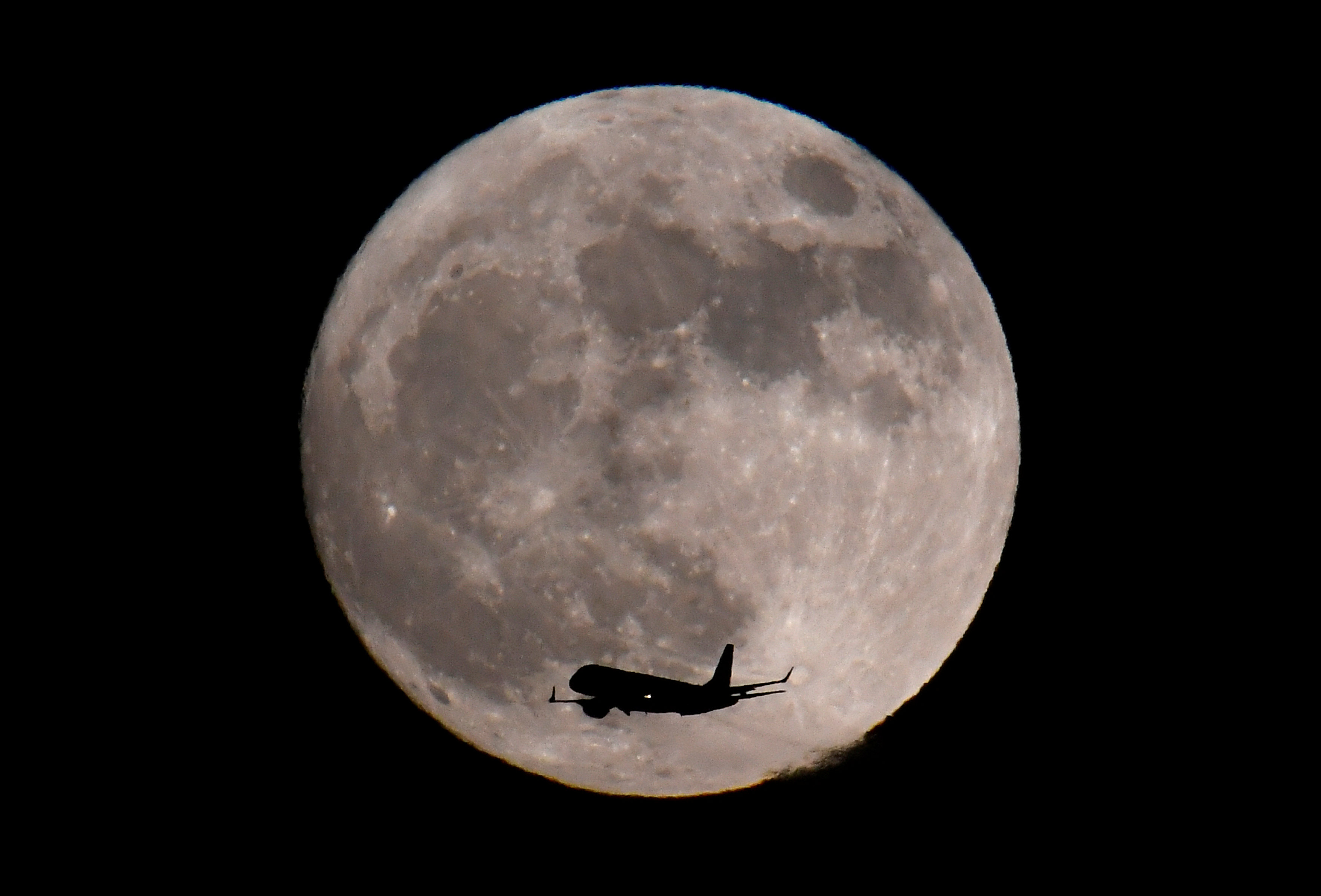 Un avión aterriza bajo la luz de la superluna en el aeropuerto de Heathrow en Londres, Reino Unido (REUTERS/Toby Melville)