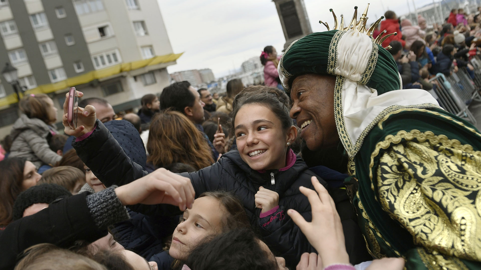 Un hombre vestido de rey mago se toma fotografías con los niños en Gijón, España (Reuters)