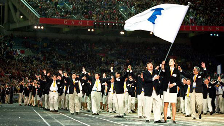 Miembros de las delegaciones de Corea del Sur y Corea del Norte llevan la bandera de la península coreana durante los JJ.OO. de Sidney en el año 2000