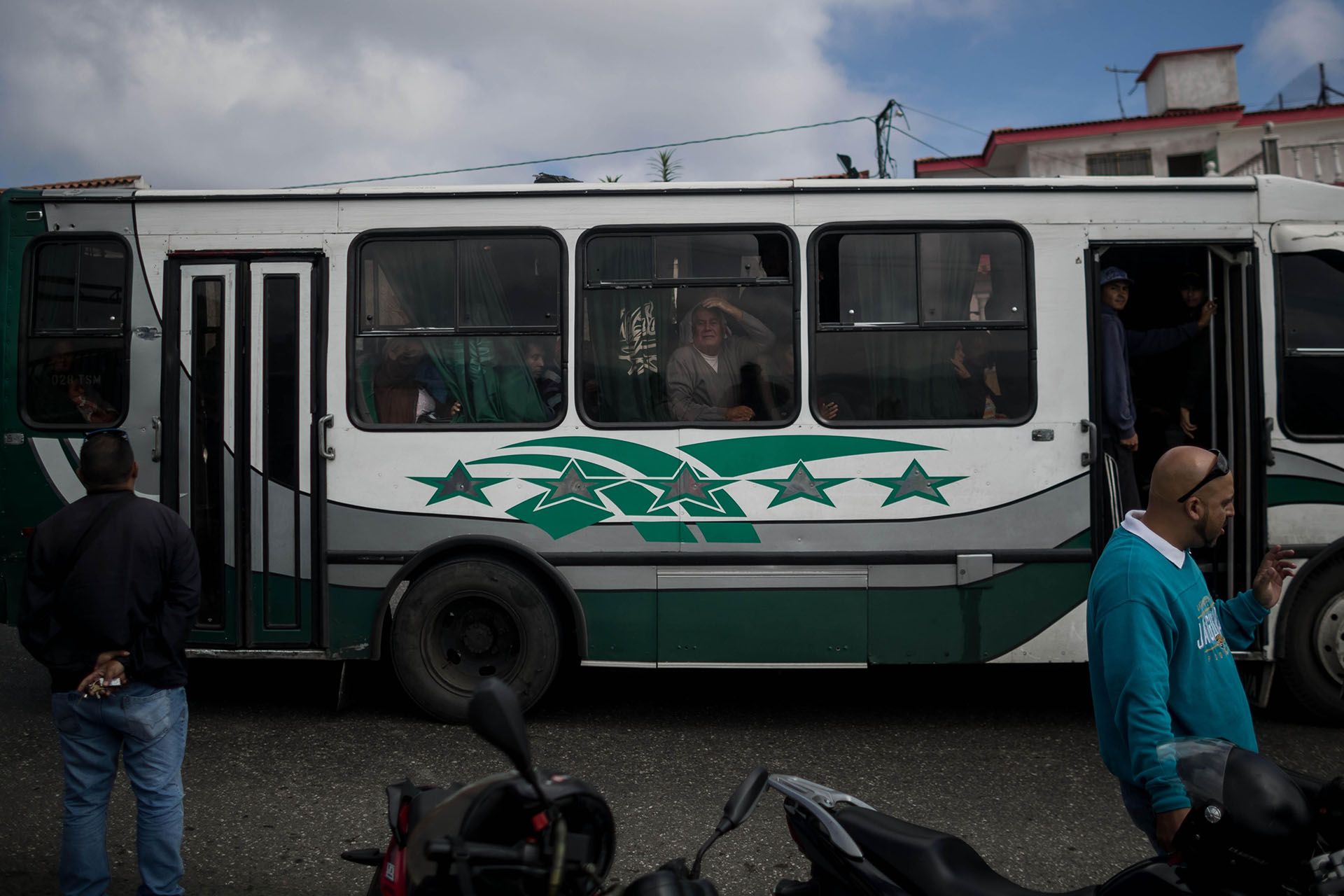 Pasajeros de un autobús observan hacia el lugar donde se realiza una operación contra el grupo liderado por el policía Óscar Pérez