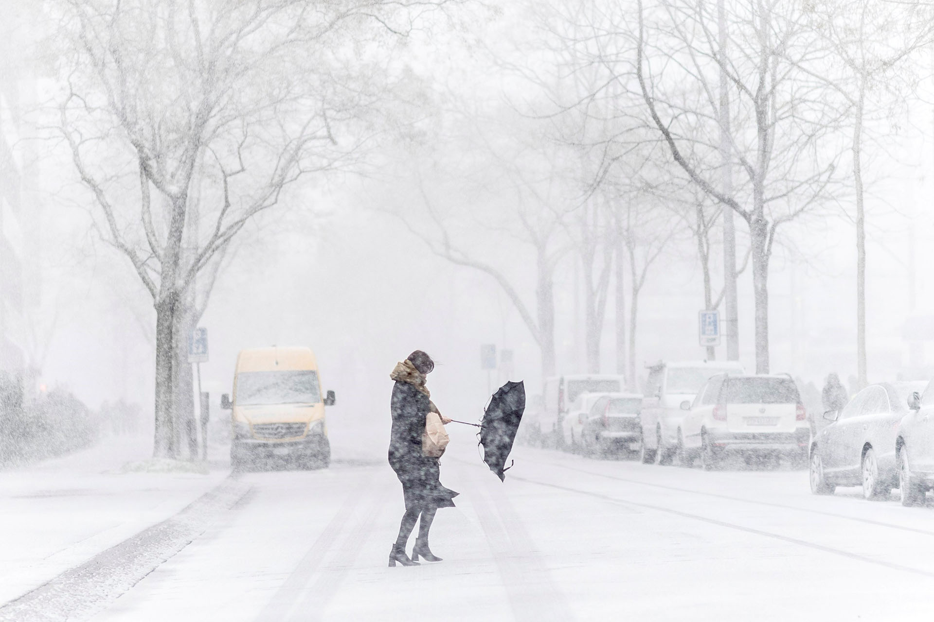 Una mujer se pelea con su paraguas durante una tormenta de nieve en una calle de Zúrich (Suiza) el 17 de enero de 2018 (EFE)