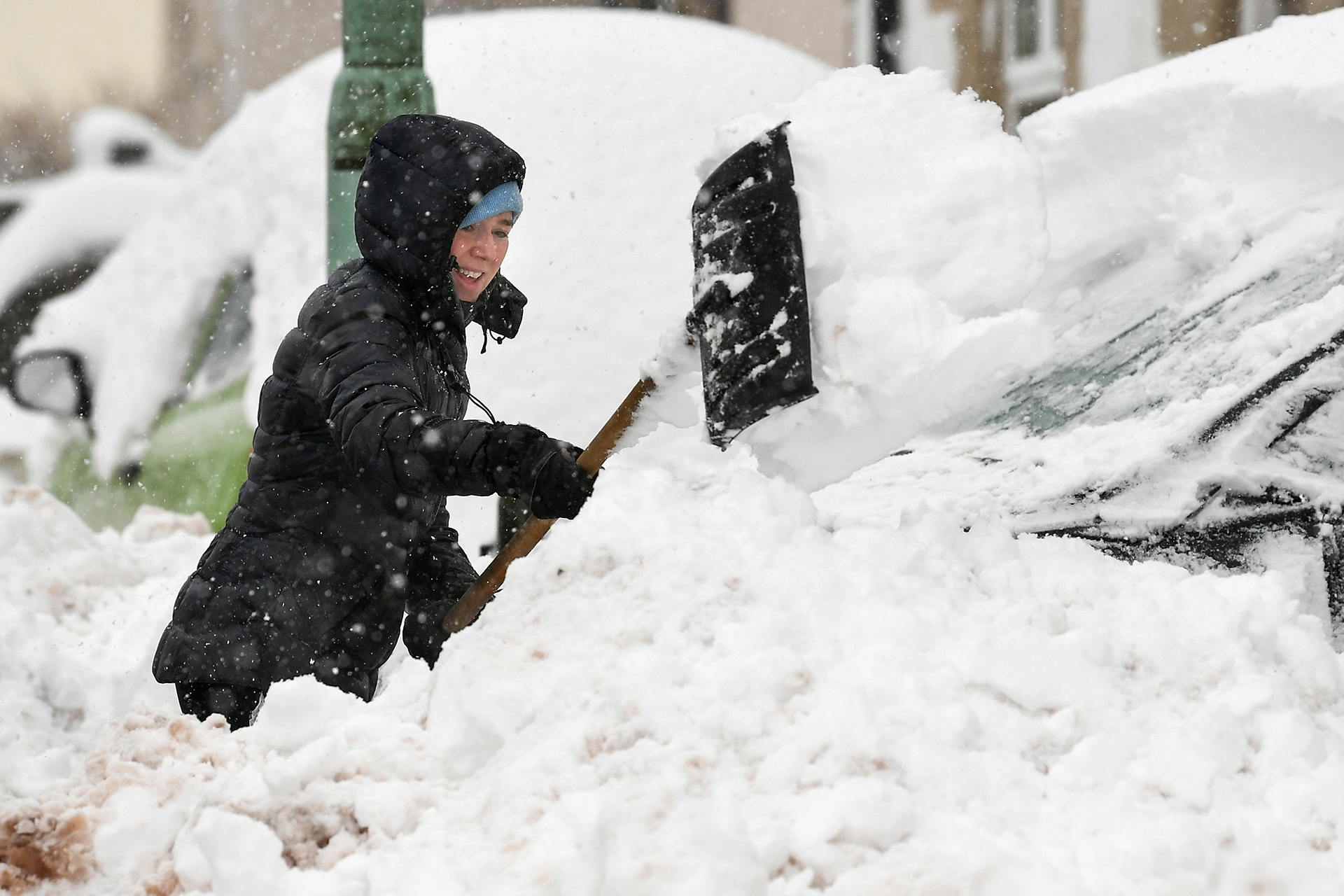 Una mujer quita la nieve de su puerta principal el 17 de enero de 2018 en Leadhills, Escocia (Getty)