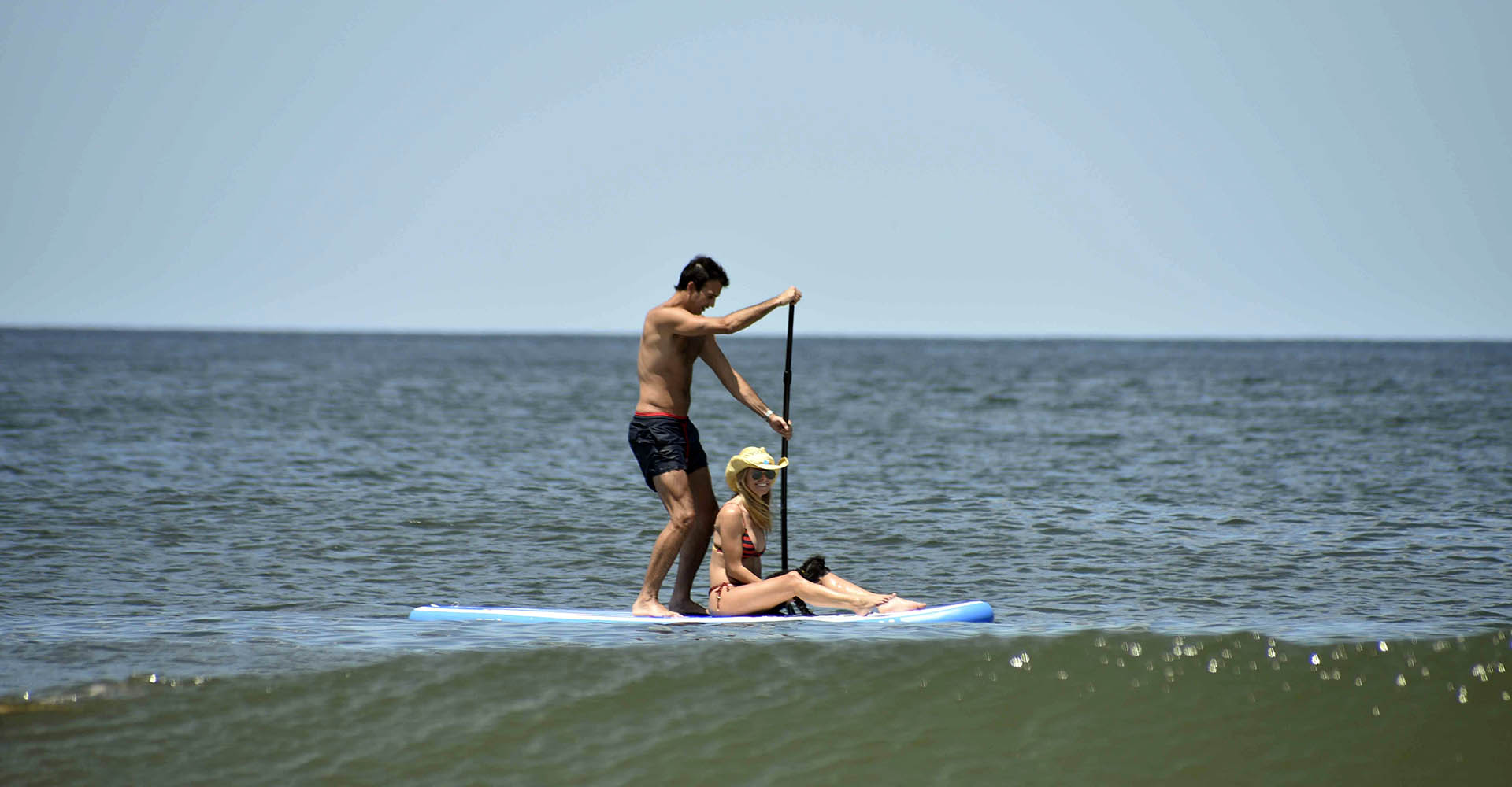 Sofia, con su pareja y su mascota disfrutaron del mar subidos a una tabla de surf