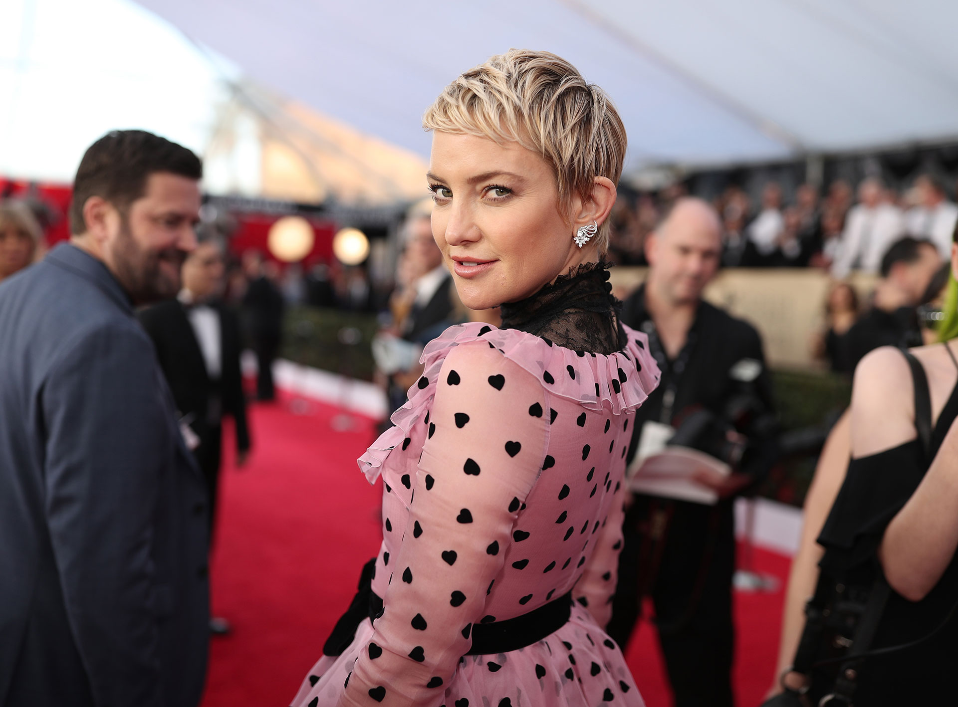 Kate Hudson con mirada cómplice por sobre su hombro. Estaba divina en su vestido rosa a lunares de Valentino. Foto by Christopher Polk/Getty Images for Turner Image.