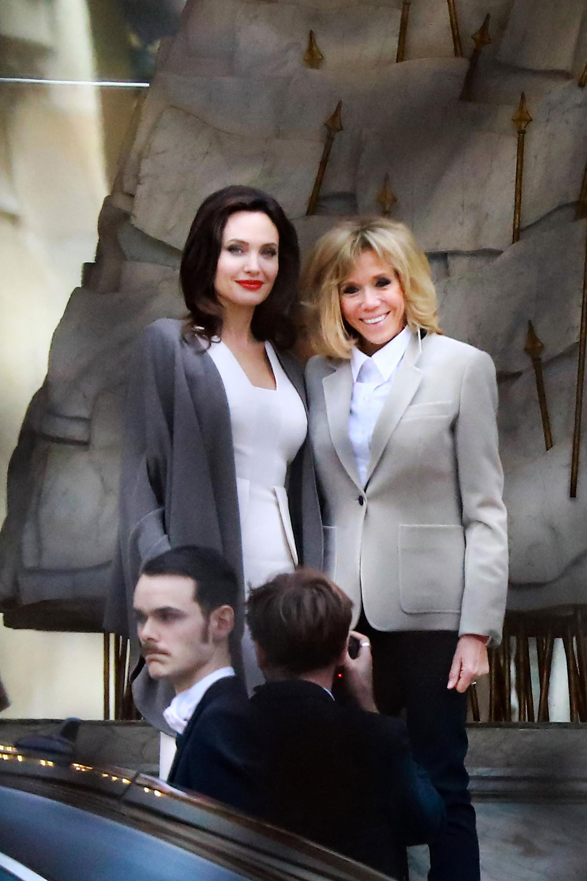 La Primera Dama de Francia eligió una camisa blanca clásica, que acompañó con un blazer gris con grandes bolsillos y pantalones oscuros