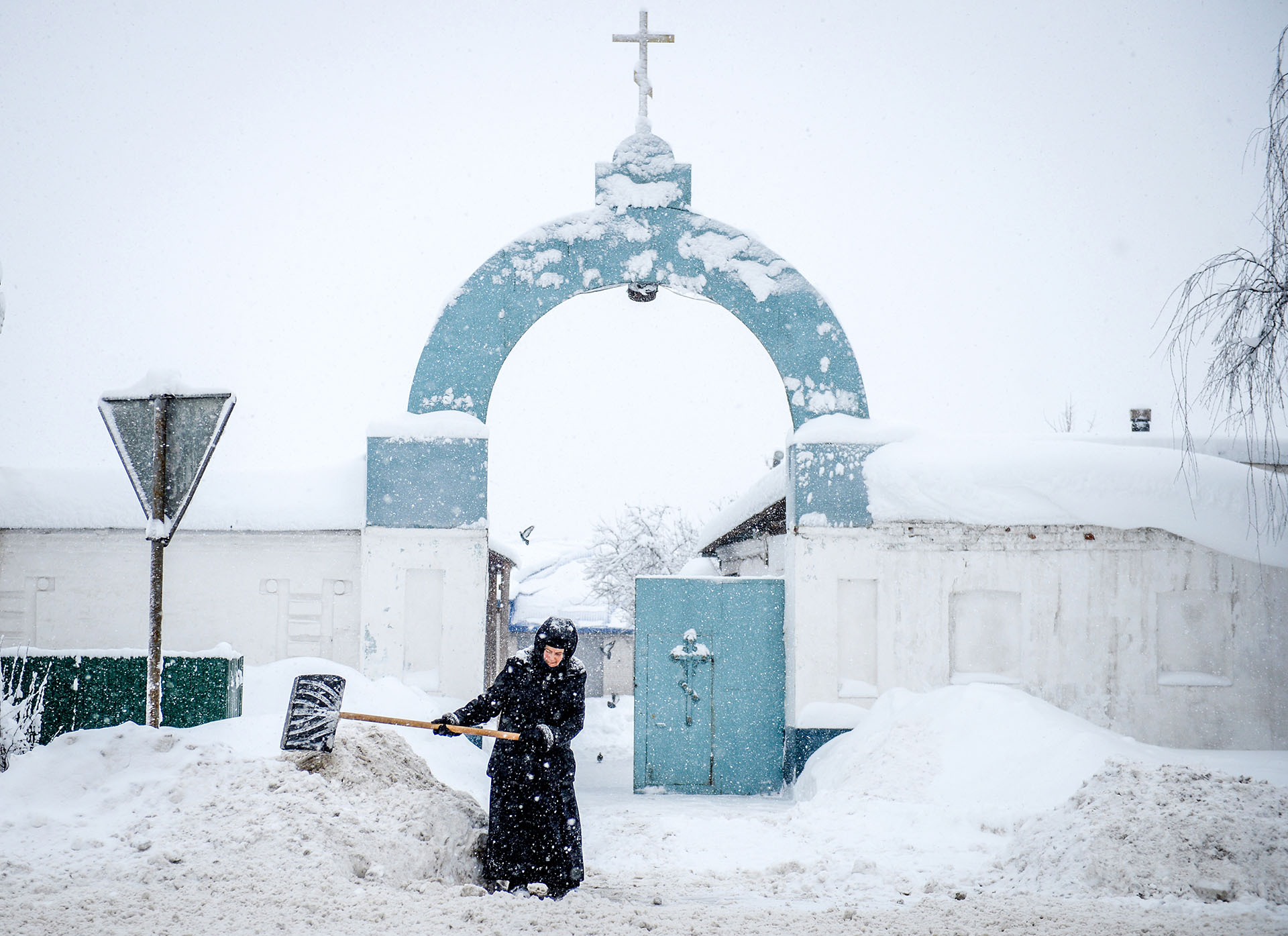Una monja barre la nieve frente a un convento en la región Vladimirsky