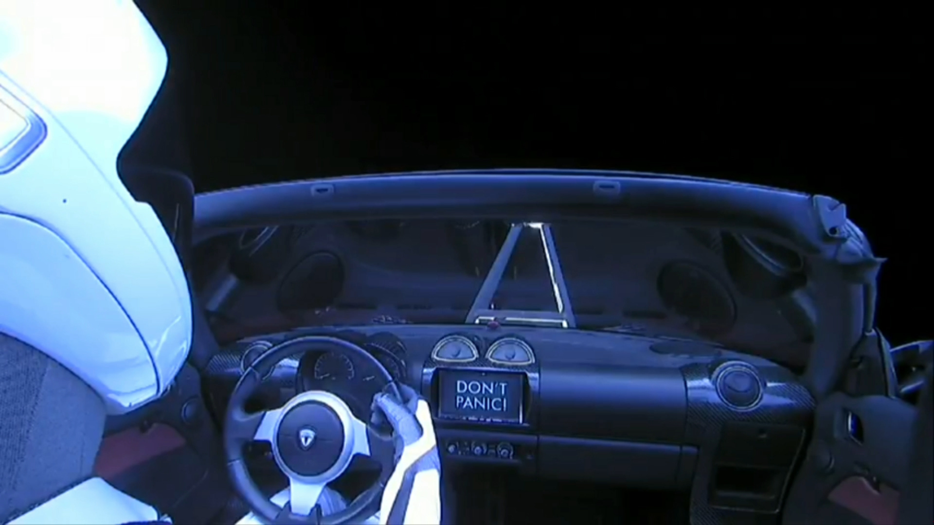 El Tesla Roadster fue lanzado al espacio con un muñeco en el asiento del conductor. En esta imagen tomada desde dentro de la nave, se puede observar un cartel que dice “No entres en pánico”