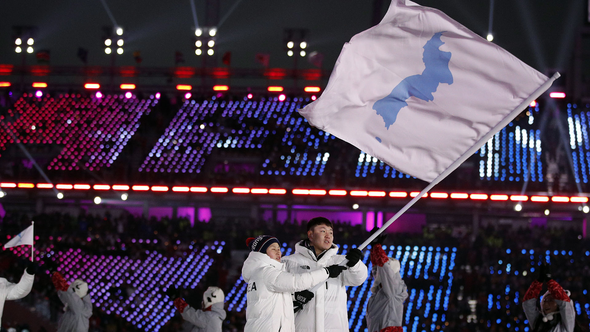 Hwang Chung-gum, de Corea del Norte, y Won Yun-jong, de Corea del Sur, portan la bandera de las dos Coreas durante la ceremonia inaugural de los Juegos