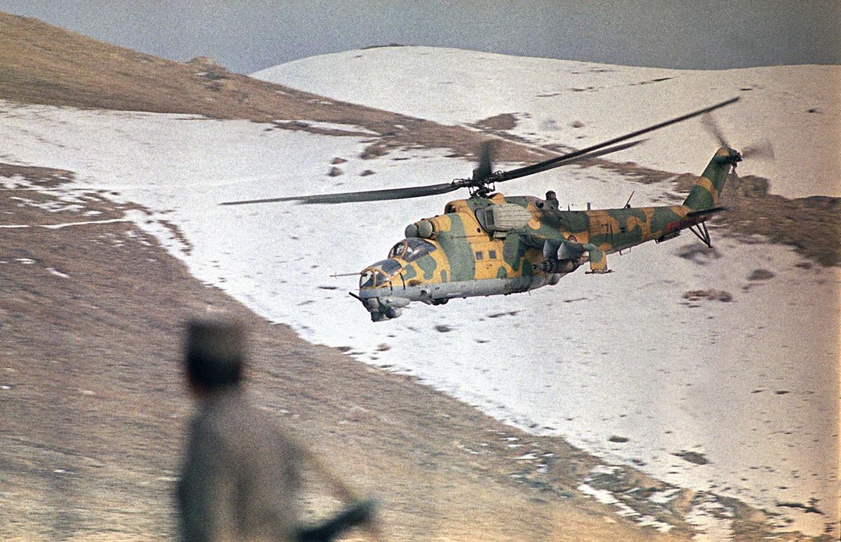 Otro símbolo de la guerra: el helicóptero de ataque Mil Mi-24 “Hind” protege un convoy que llevaba combustible y comida a Kabul en 1989 (AP)