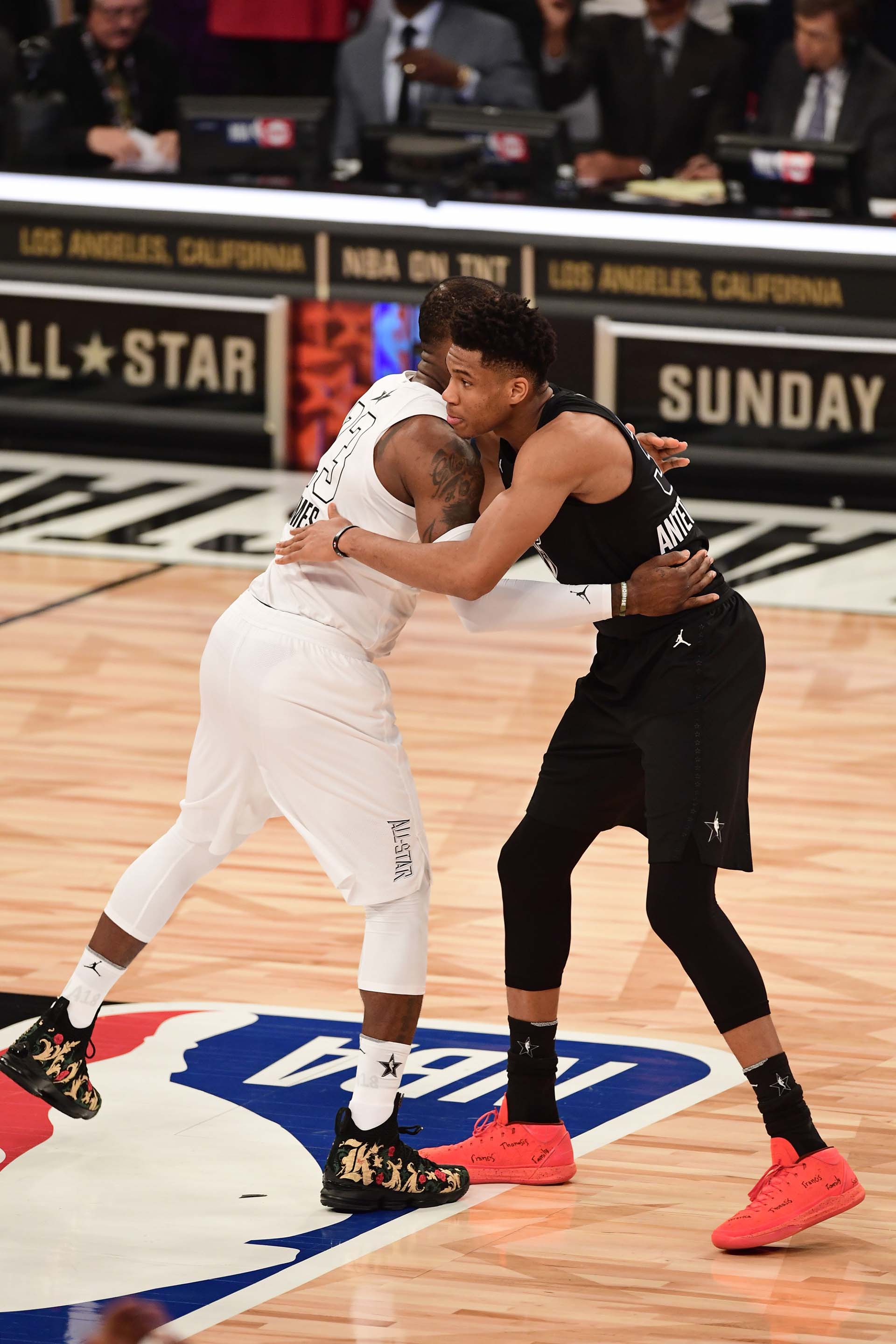 LeBron James y Giannis Antetokounmpo se abrazan en el campo