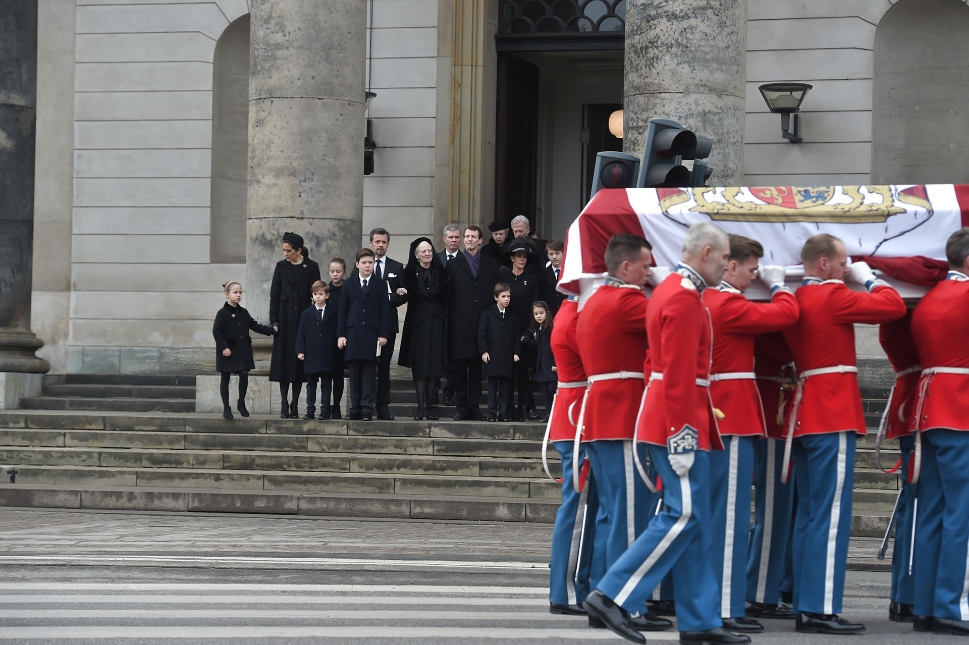 La familia real de Dinamarca observa a los soldados que llevan el féretro y que contiene los restos del príncipe Enrik, tras finalizar el servicio religioso en su memoria en la capilla del Palacio de Christiansborg, en Copenhague