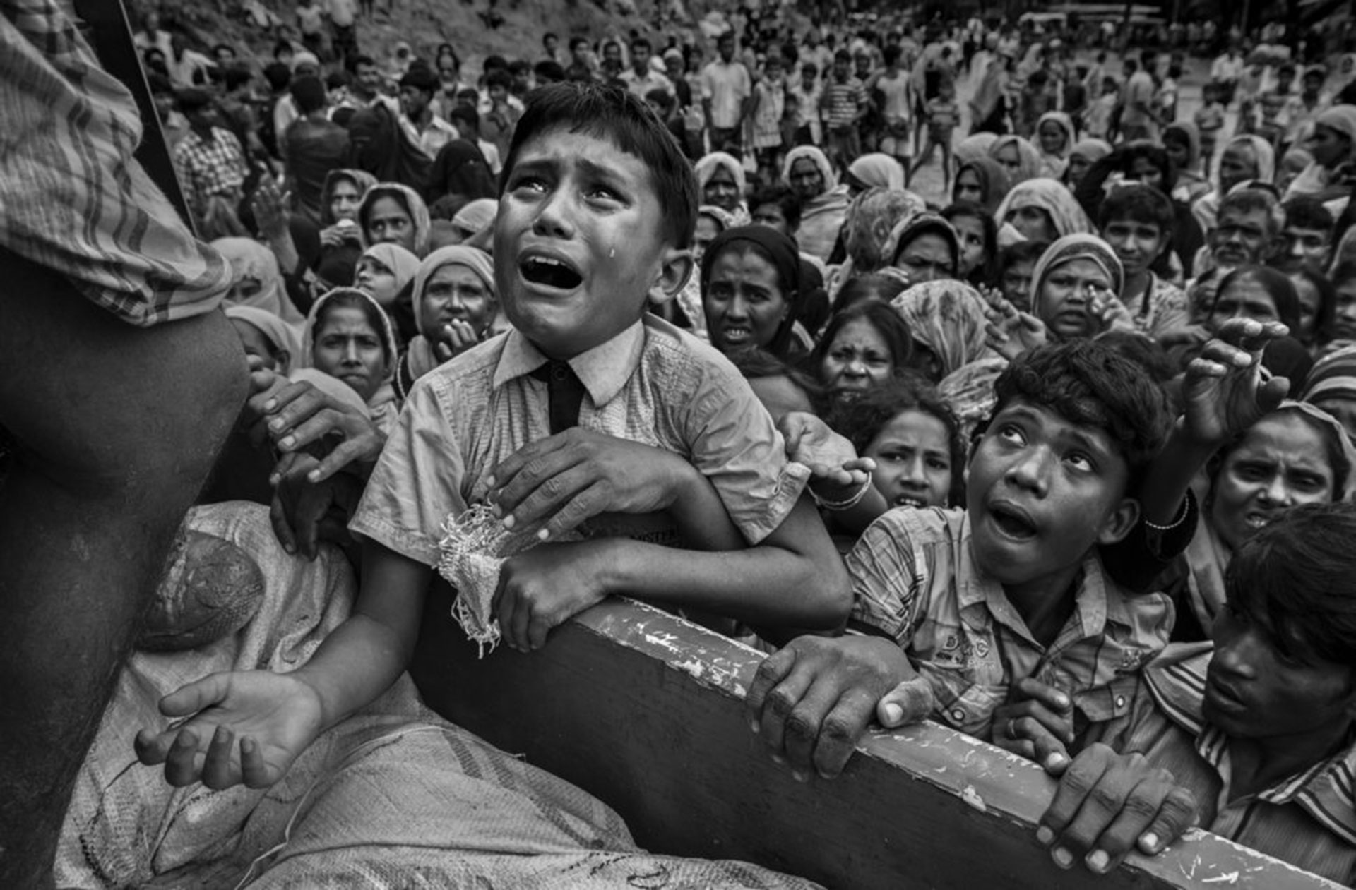Competencia “Profesional” – Categoría “Noticias y Asuntos de Actualidad”: un niño refugiado de Rohingya desesperado por ayuda llora mientras sube a un camión que distribuye ayuda a una ONG local cerca del campamento de refugiados de Balukali el 20 de septiembre de 2017, en Cox’s Bazar, Bangladesh. (Gentileza Sony World Photography Awards)