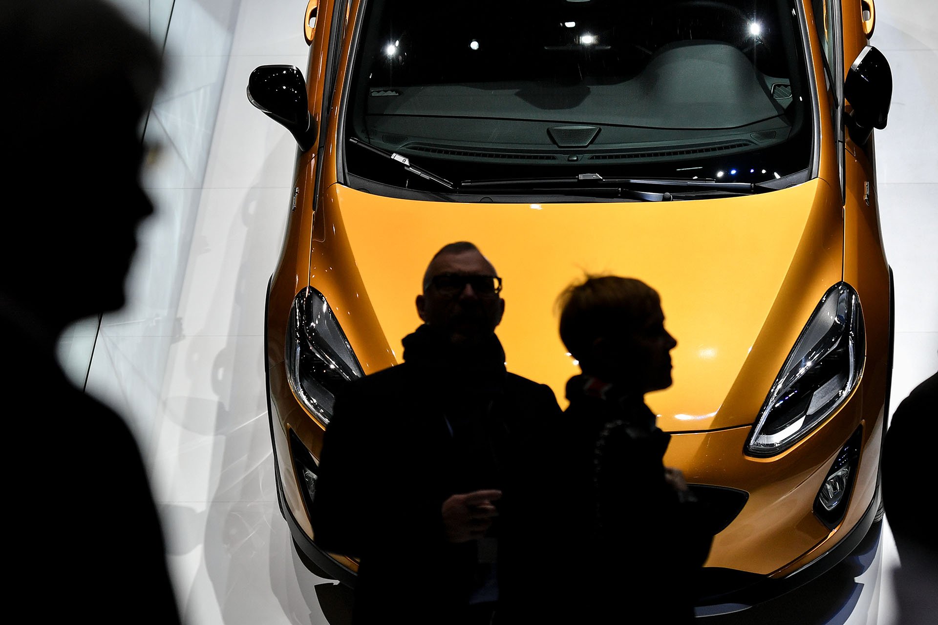 Un visitante pasa por delante de un Fiesta que cuelga del stand de Ford. La cita helvética, la de mayor continuidad de todos los salones del mundo, celebra su edición número 88 y espera recibir a más de 700 mil personas