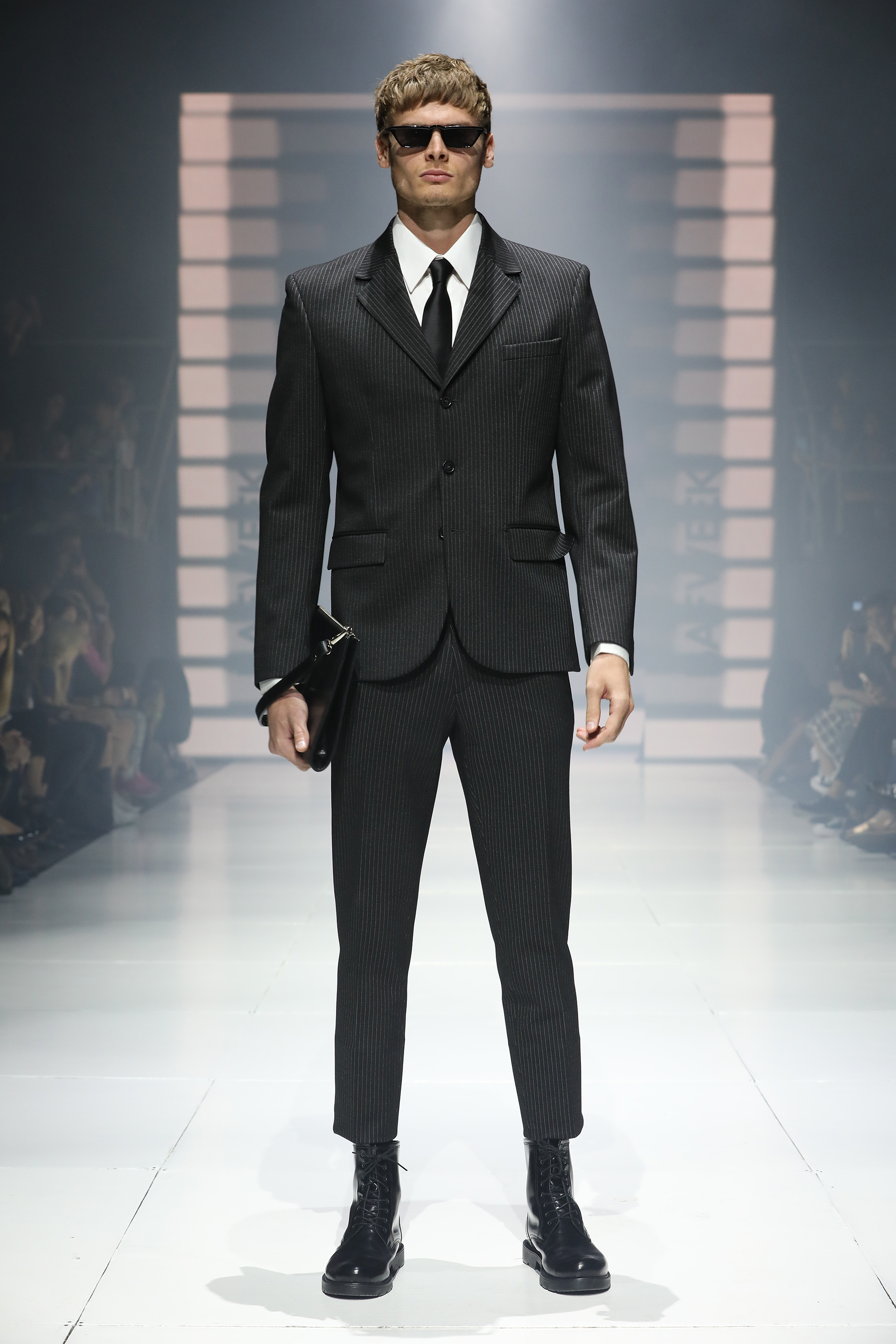 Mis Íntimos Amigos. Clásico traje a rayas negro, con camisa blanca y corbata de seda negra. El detalle fashionista: el corte crop del pantalón y las botas de charol