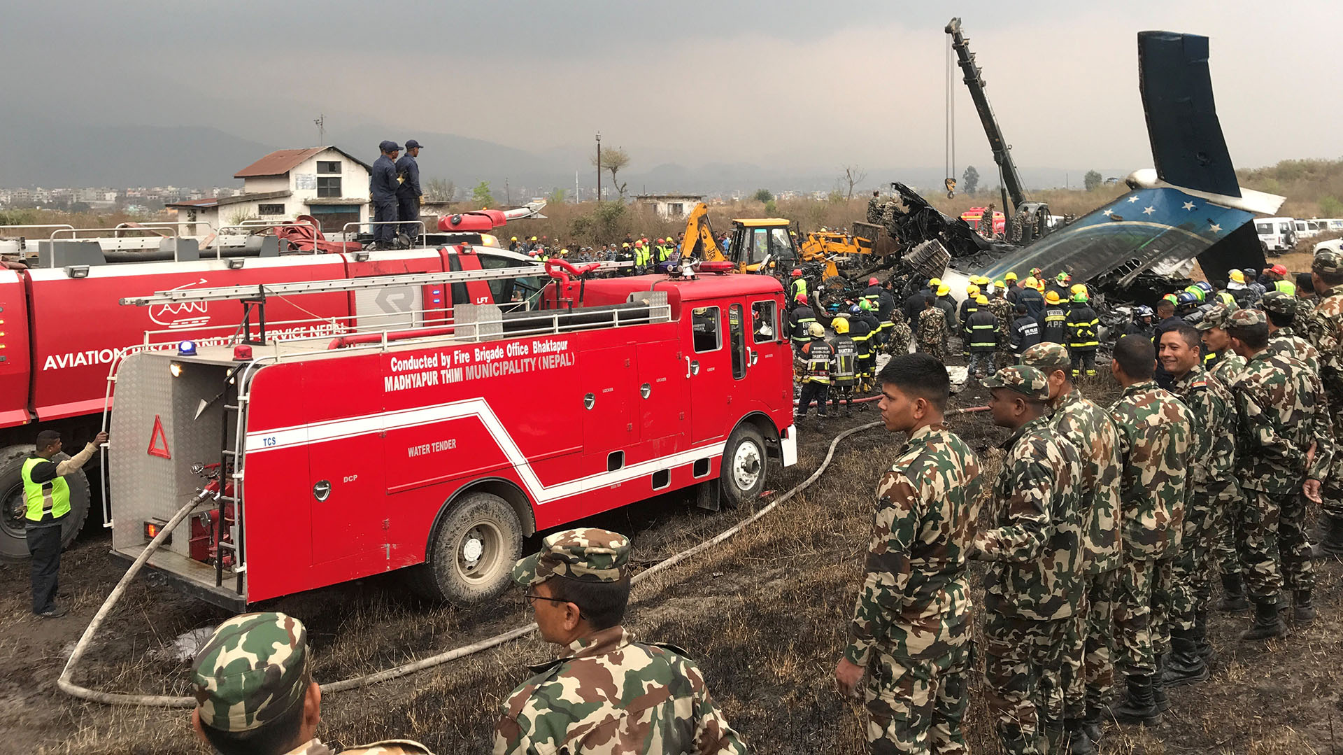 Los vehículos de los bomberos que apagaron el incendio del avión y los militares que cercaron el lugar tras el accidente