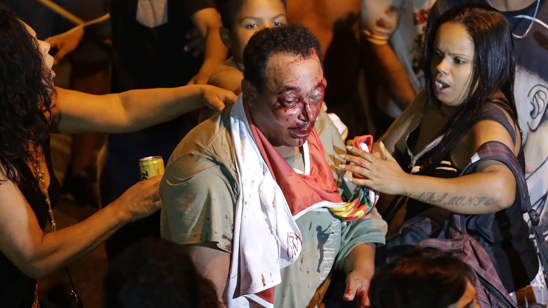 Simpatizantes del ex presidente intentan asistir a un hombre que estuvo involucrado en una pelea afuera del sindicato. (AP Photo/Nelson Antoine)