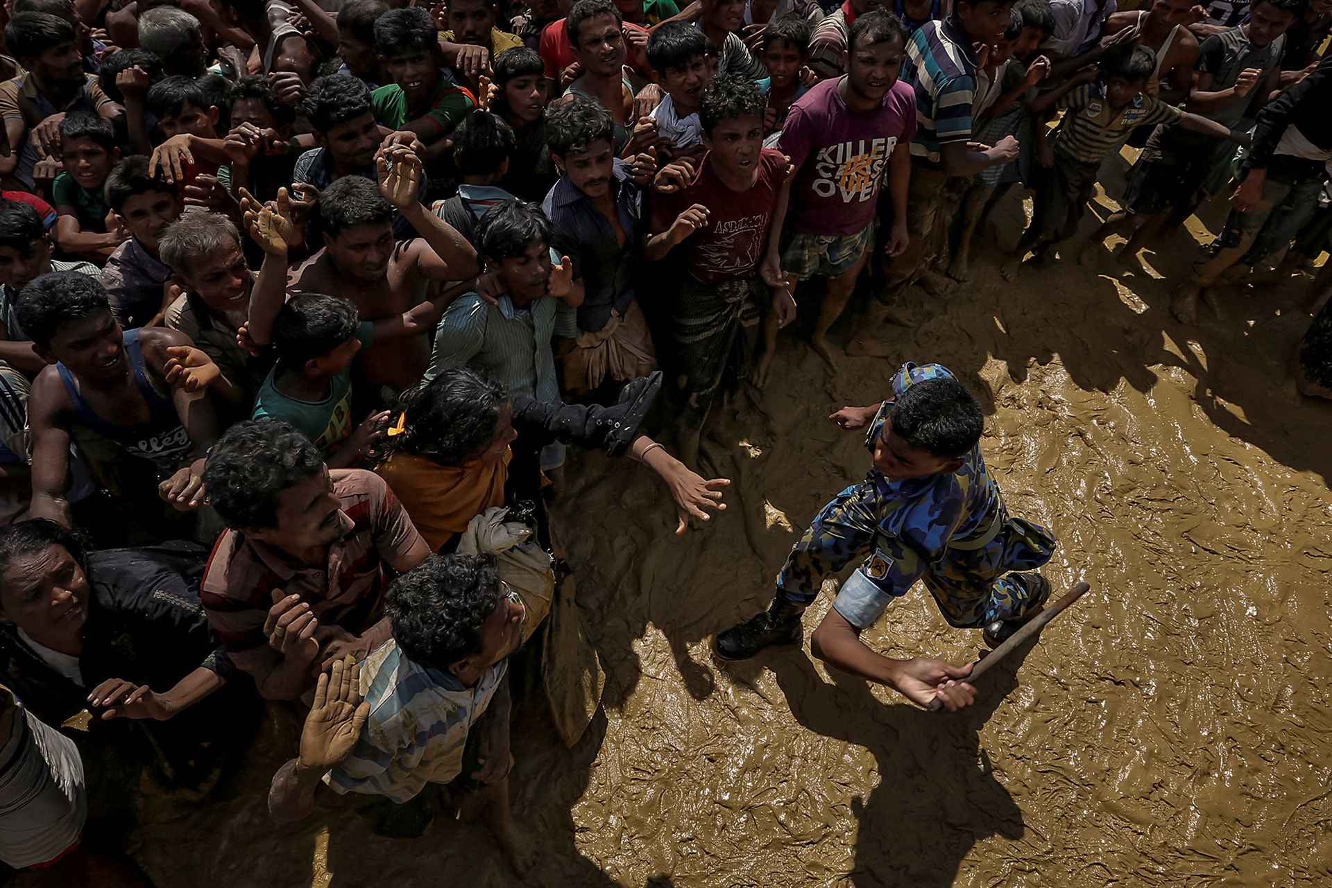 Un oficial de seguridad intenta controlar a los refugiados rohingya que esperan recibir ayuda en Cox’s Bazar, Bangladesh, el 21 de septiembre de 2017. (Cathal McNaughton)