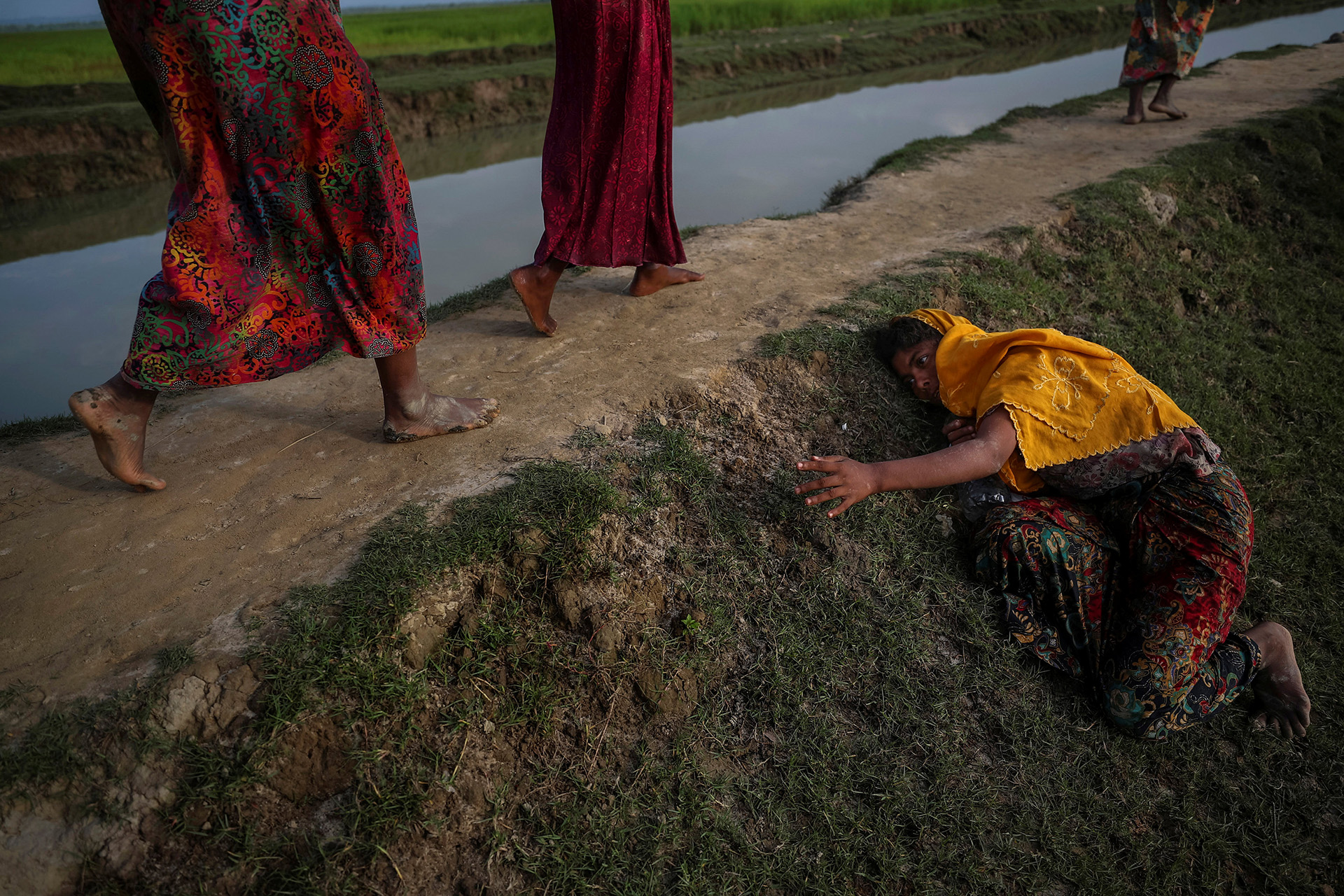 Un agotado refugiado rohingya que huye de la violencia en Myanmar pide ayuda a otros que cruzan hacia Palang Khali, cerca de Cox’s Bazar, Bangladesh, el 2 de noviembre de 2017. (Hannah McKay)