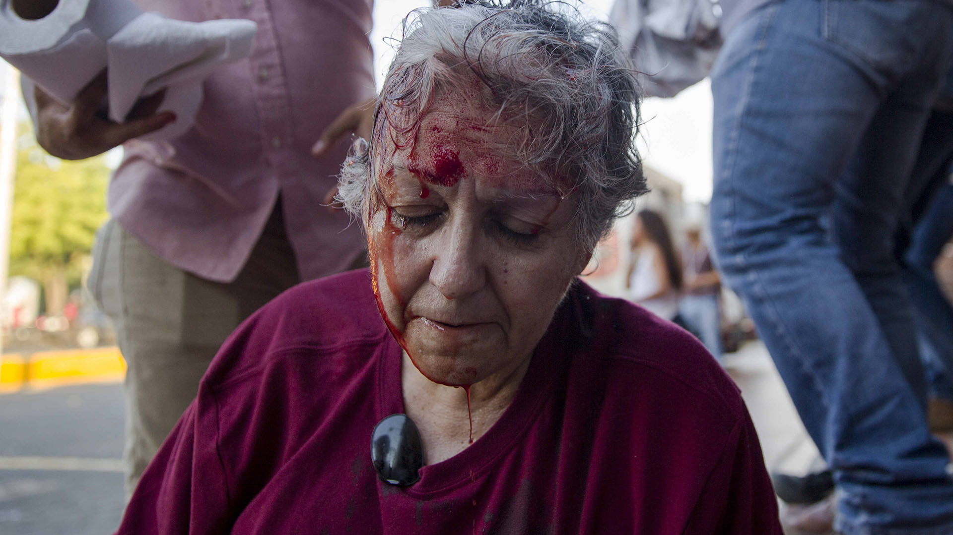 NI001. MANAGUA (NICARAGUA), 18/04/2018.- La activista de la Red de Mujeres contra la Violencia Ana Quiroz sangra en el suelo tras ser golpeada por las fuerzas de choque del gobierno de Ortega