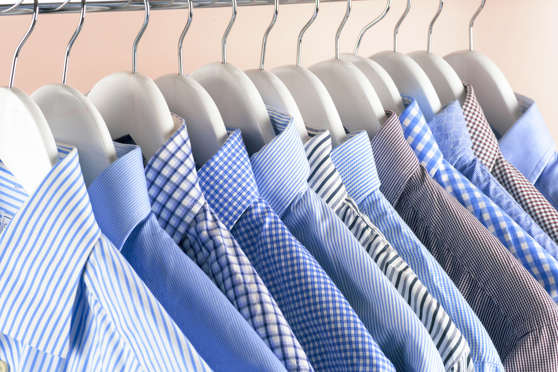 Camisas planchadas y colgadas en perchas. Ordenadas por color y diseños para lograr identificar más rápido cual se desea usar (Getty Images)