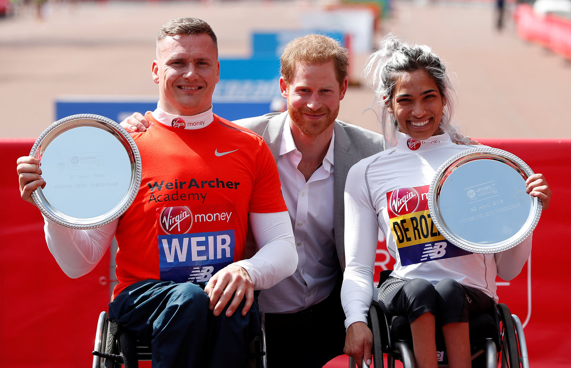 El principe Harry junto a la australiana Madison de Rozario y el británico David Weir, ganadores de sus categorpias
