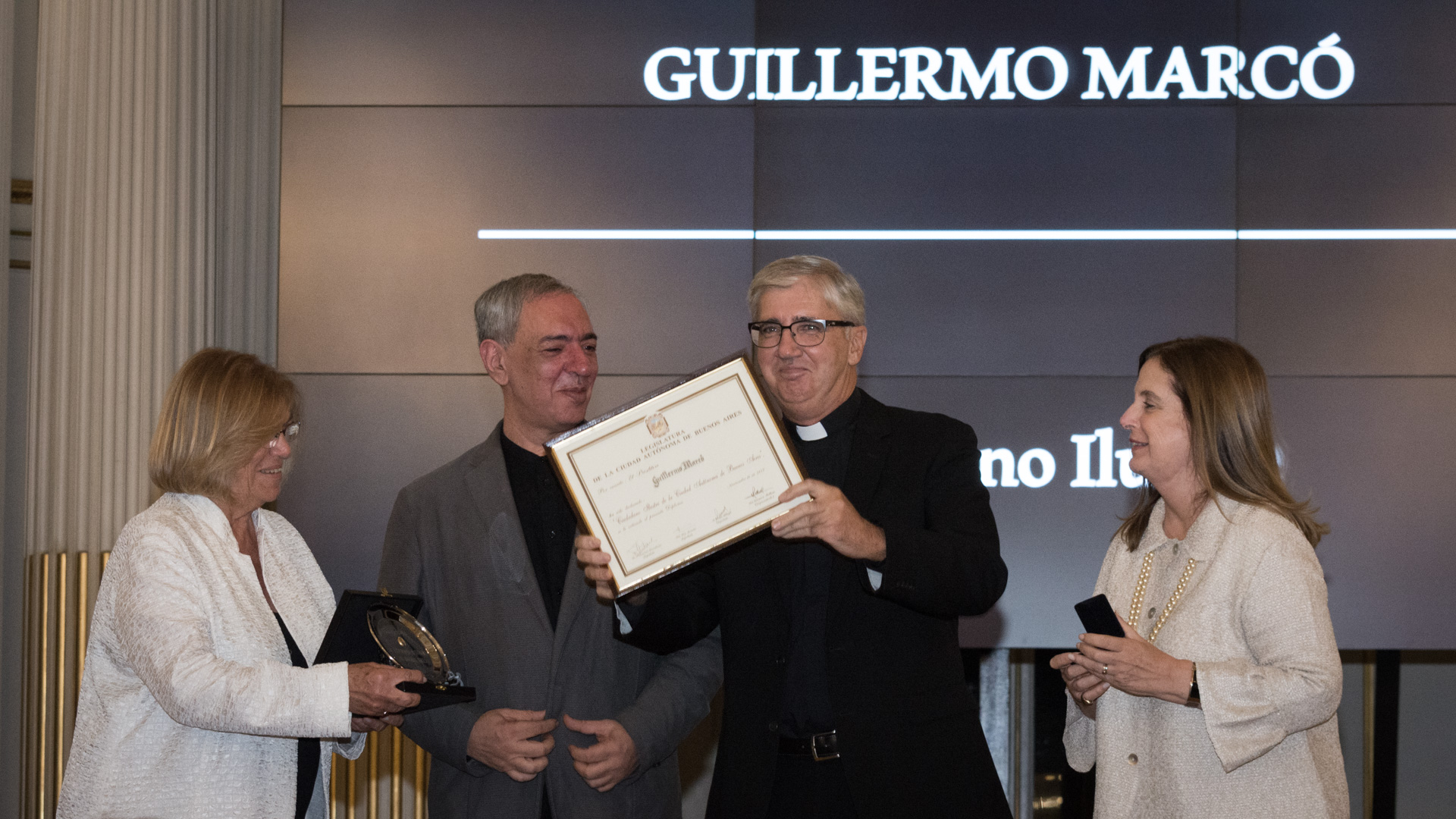 La legisladora porteña Lía Rueda junto a los diputados Omar Abboud y Carmen Polledo hacen entrega de la distinción como Ciudadano Ilustre de la Ciudad de Buenos Aires al Presbítero Guillermo Marcó