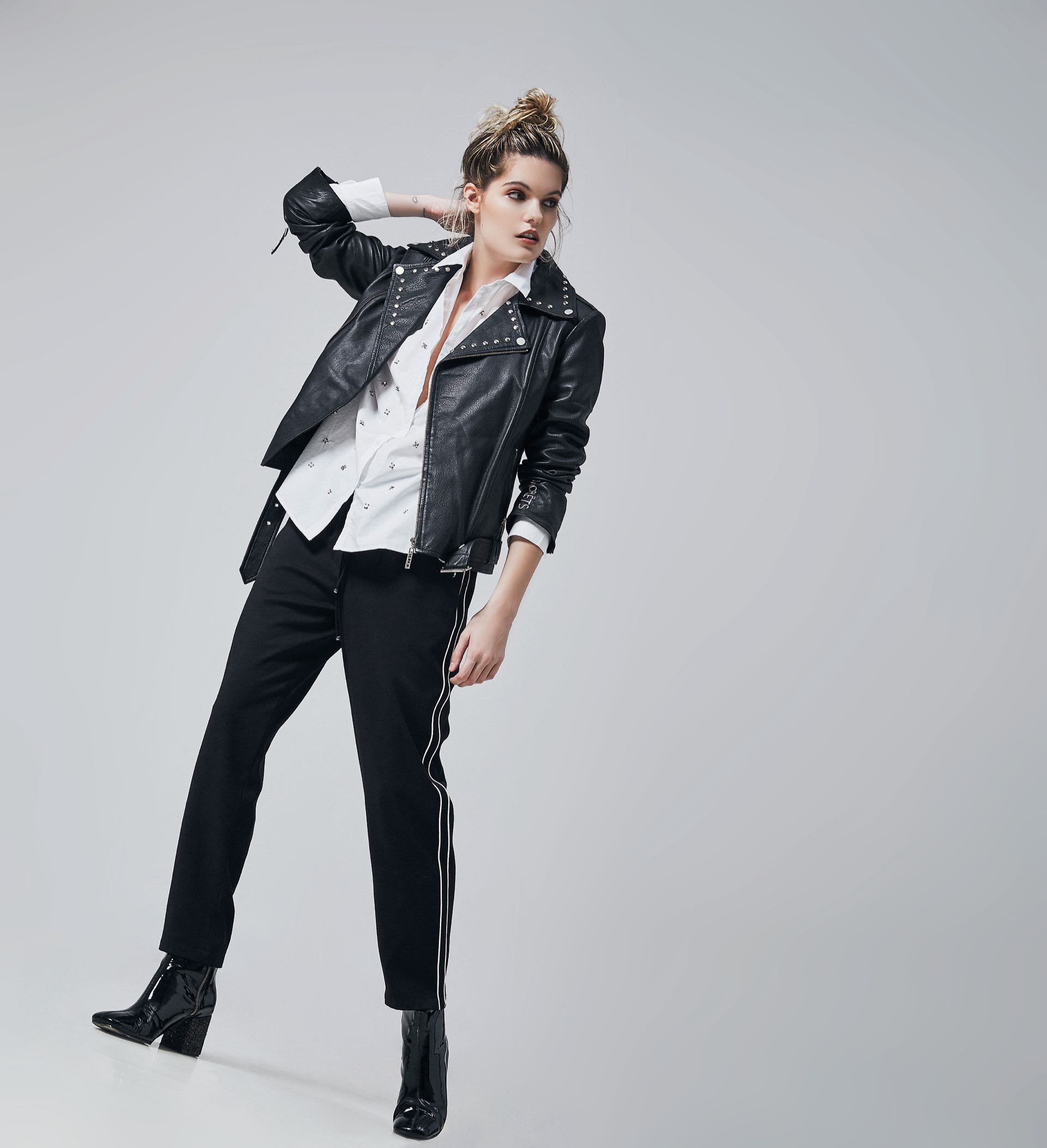 Campera de cuero ($ 15.800, Uma), pantalón con línea blanca en el lateral ($ 2.290, Las Pepas), camisa con perlas ($ 2.900, Kosiuko) y botas de charol ($ 6.800, Vitamina).