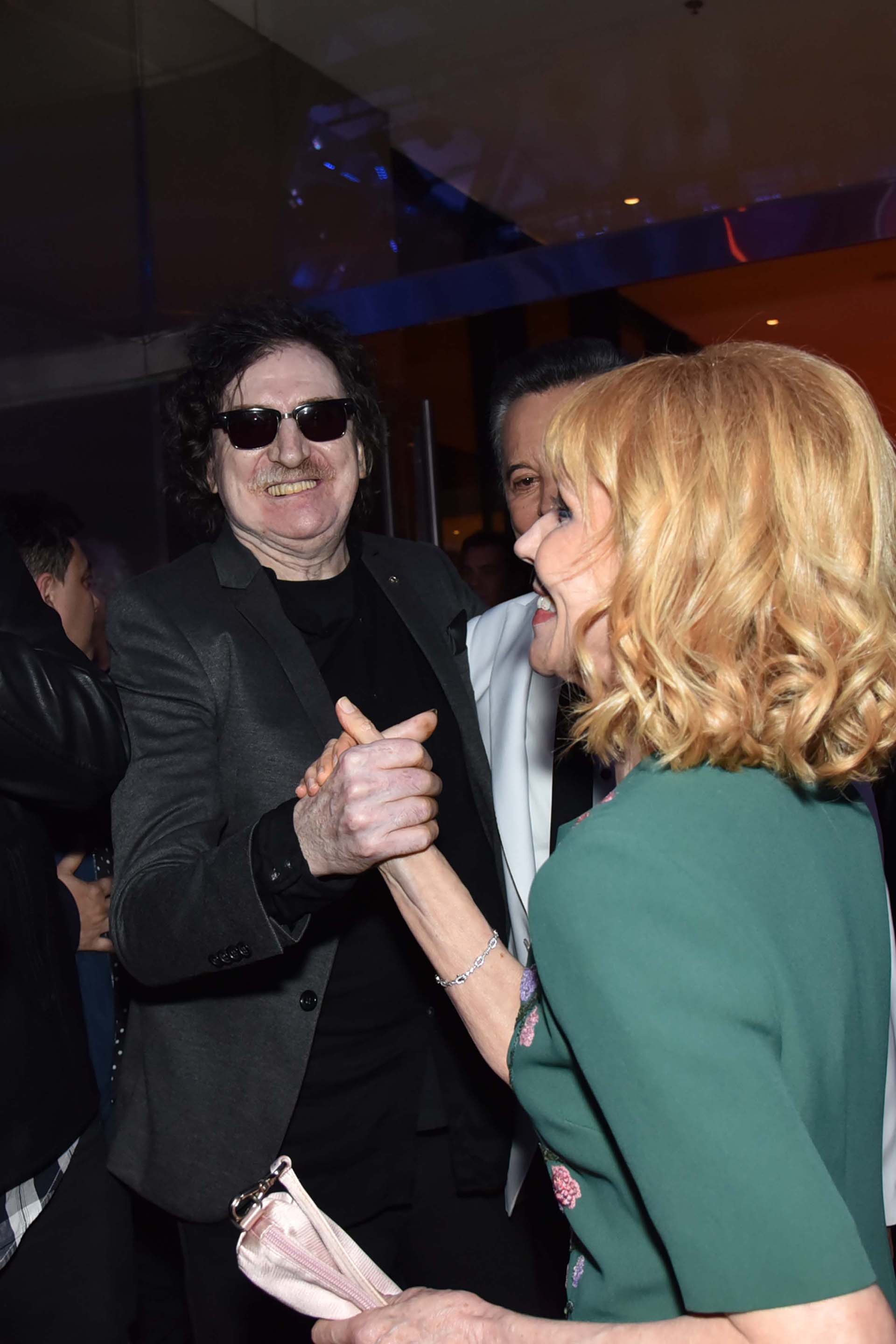 Charly García, abrazado a Palito, le da la mano a Evangelina Salazar