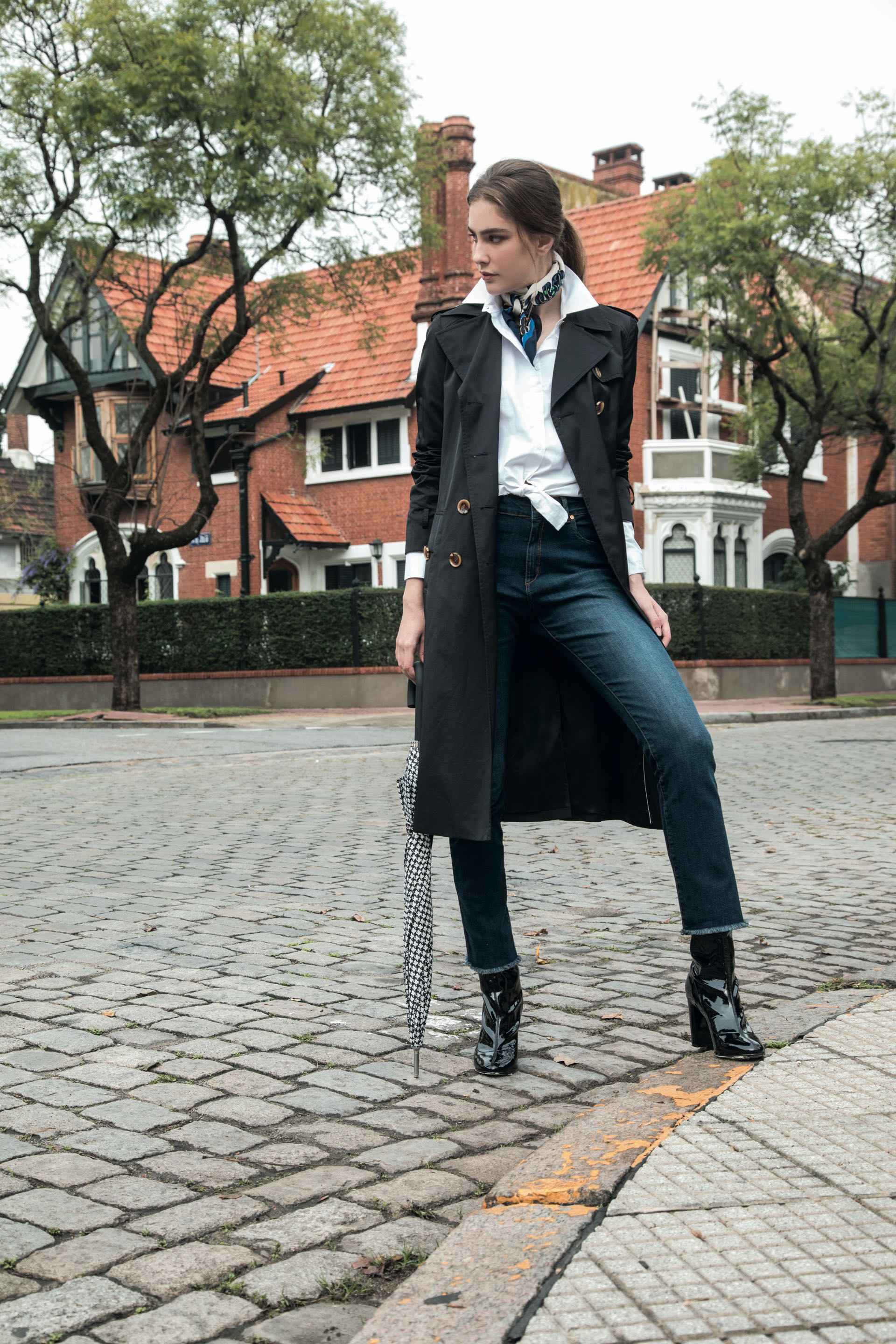 Trench impermeable ($ 6.500, Uma), camisa con nudo en la cintura ($ 1.980, La Cofradía), jean recto ($ 2.800, Vitamina), botas de vinilo ($ 2.900, a pie) y paraguas ($ 576, Perramus). (Foto: Fernando Venegas/ Para Ti)
