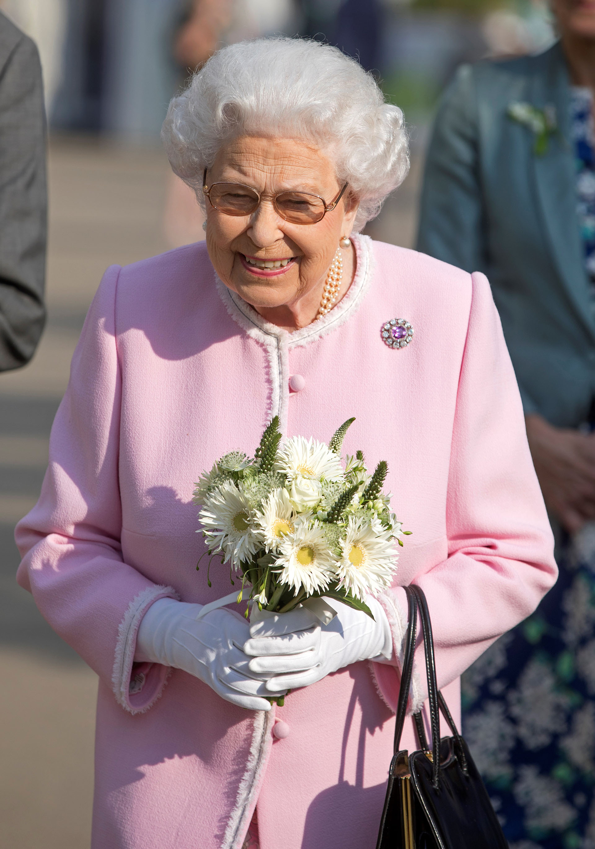 La reina paseó por los jardines con un ramo de flores en sus manos
