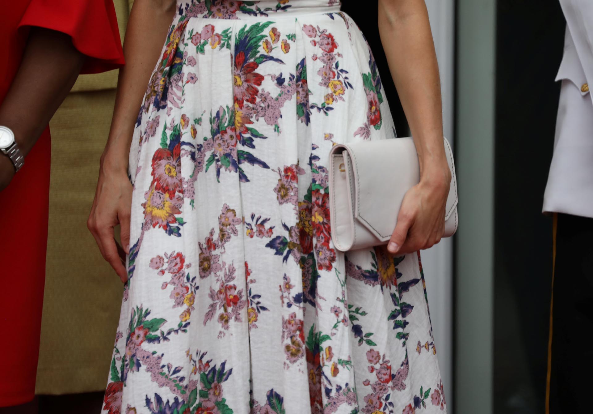 El detalle del estampado floral de su falda y de su clutch rectangular