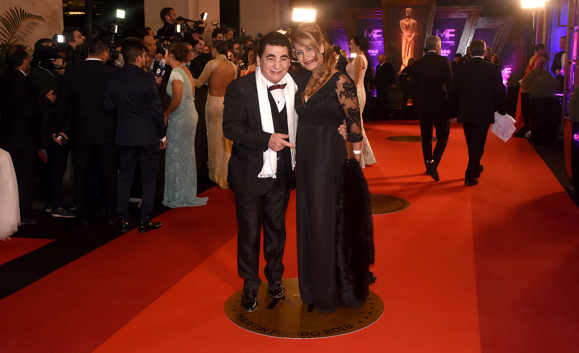 El infaltable miembro de Aptra Cacho Rubio, traje negro clásico y chaleco con moño bordó y su icónica chalina blanca. Alejandra Rubio con vestido negro bordado en la parte superior, mangas de tul y lo acompañó con estola de piel.