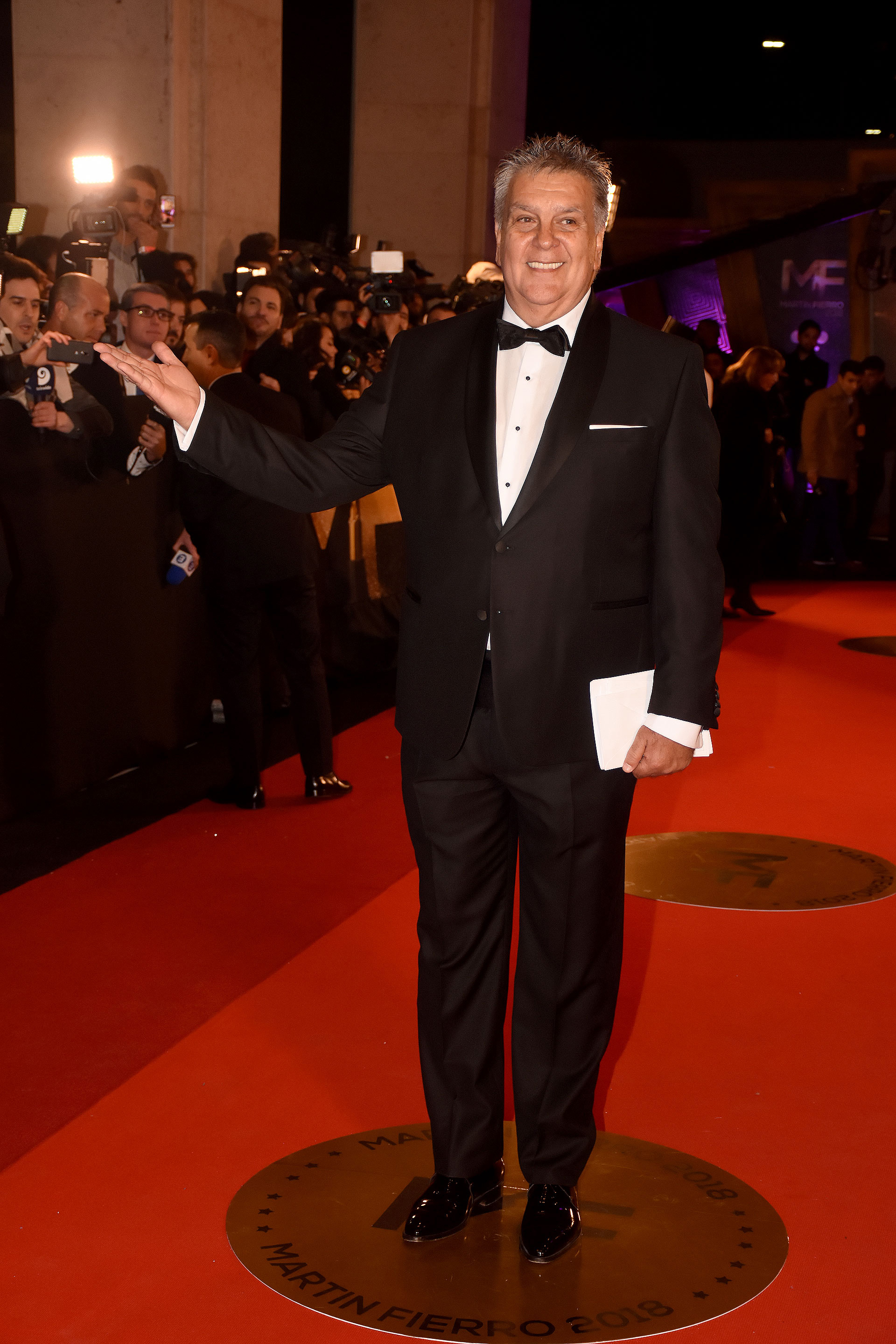 El presidente de APTRA Luis Ventura con traje negro, camisa blanca con botones forrados, zapatos acharolados y pochette en el saco.