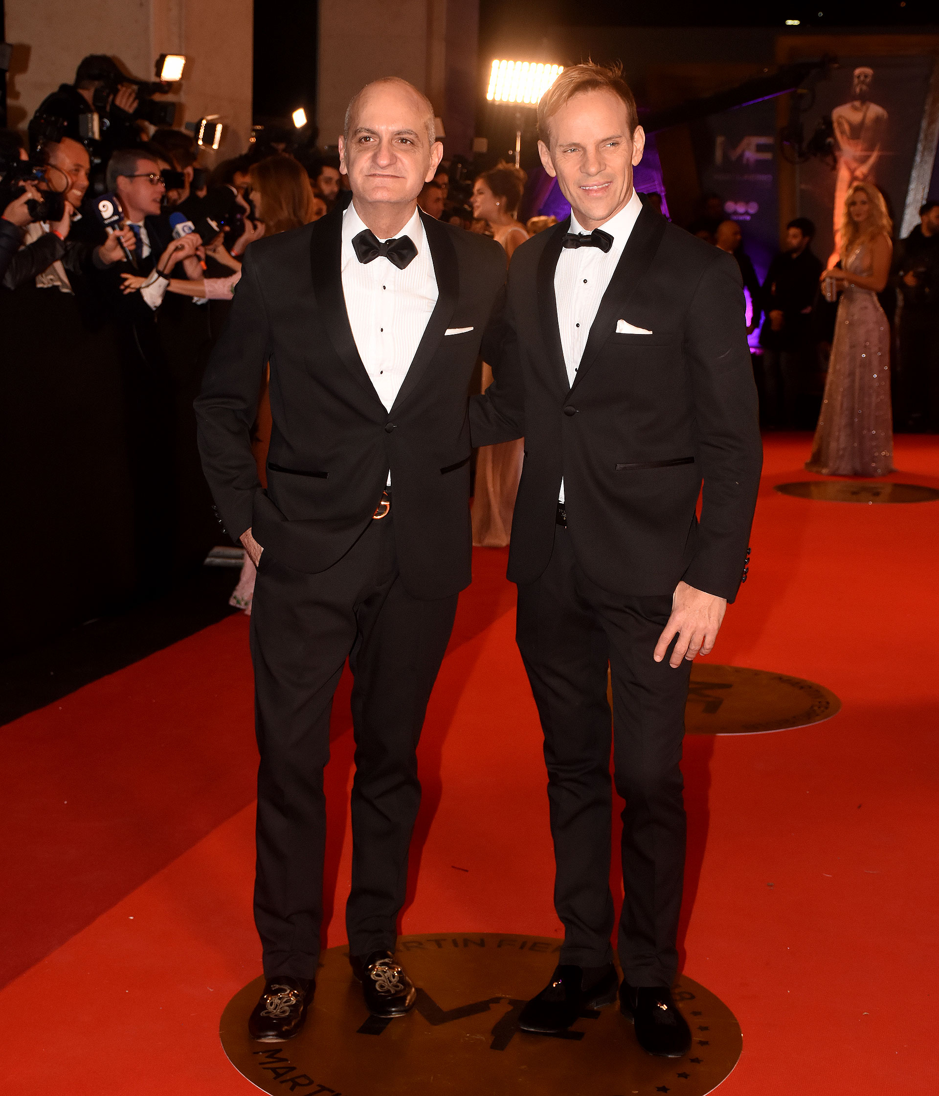 Laurencio Adot y Thiago Pinheiro, ambos en black tie con mocasines y pochette blanco.