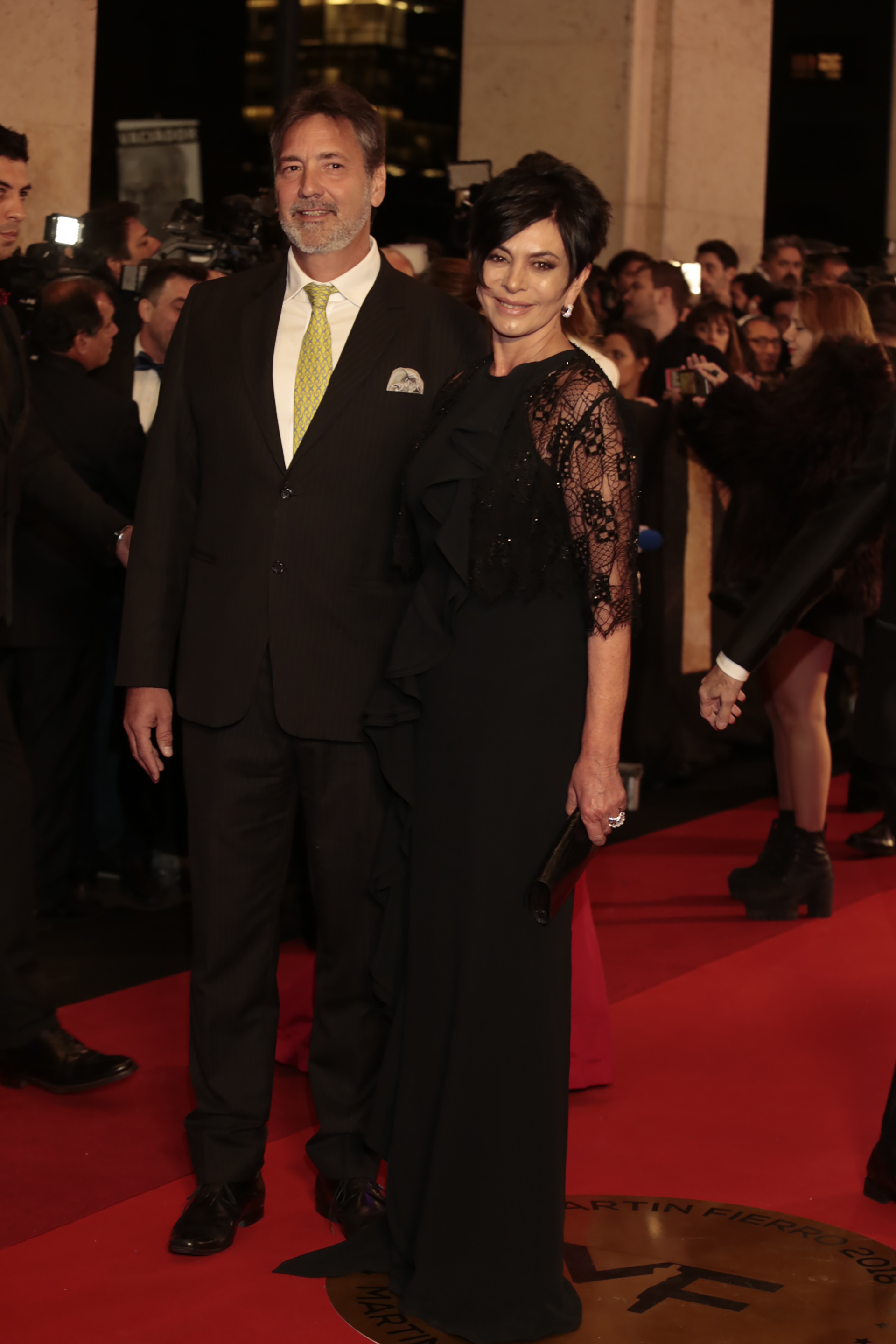 Mónica Gutiérrez y su marido. Ella eligió un diseño de Menage a Trois en negro con mangas de encaje y jabot a lo largo de todo el vestido. Él la acompañó con un traje clásico con corbata en color verde manzana.